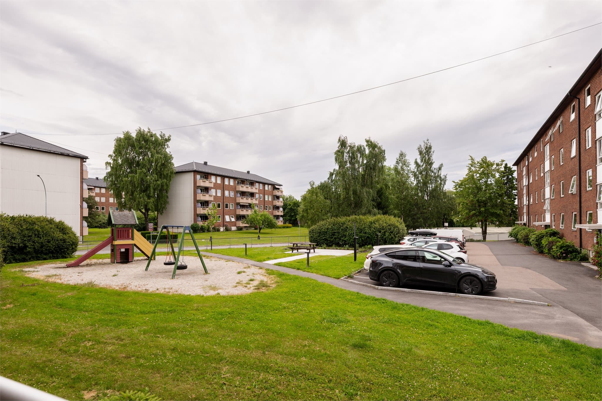 Fra balkongen ser man ut over borettslagets grønne og barnevennlige fellesarealer.