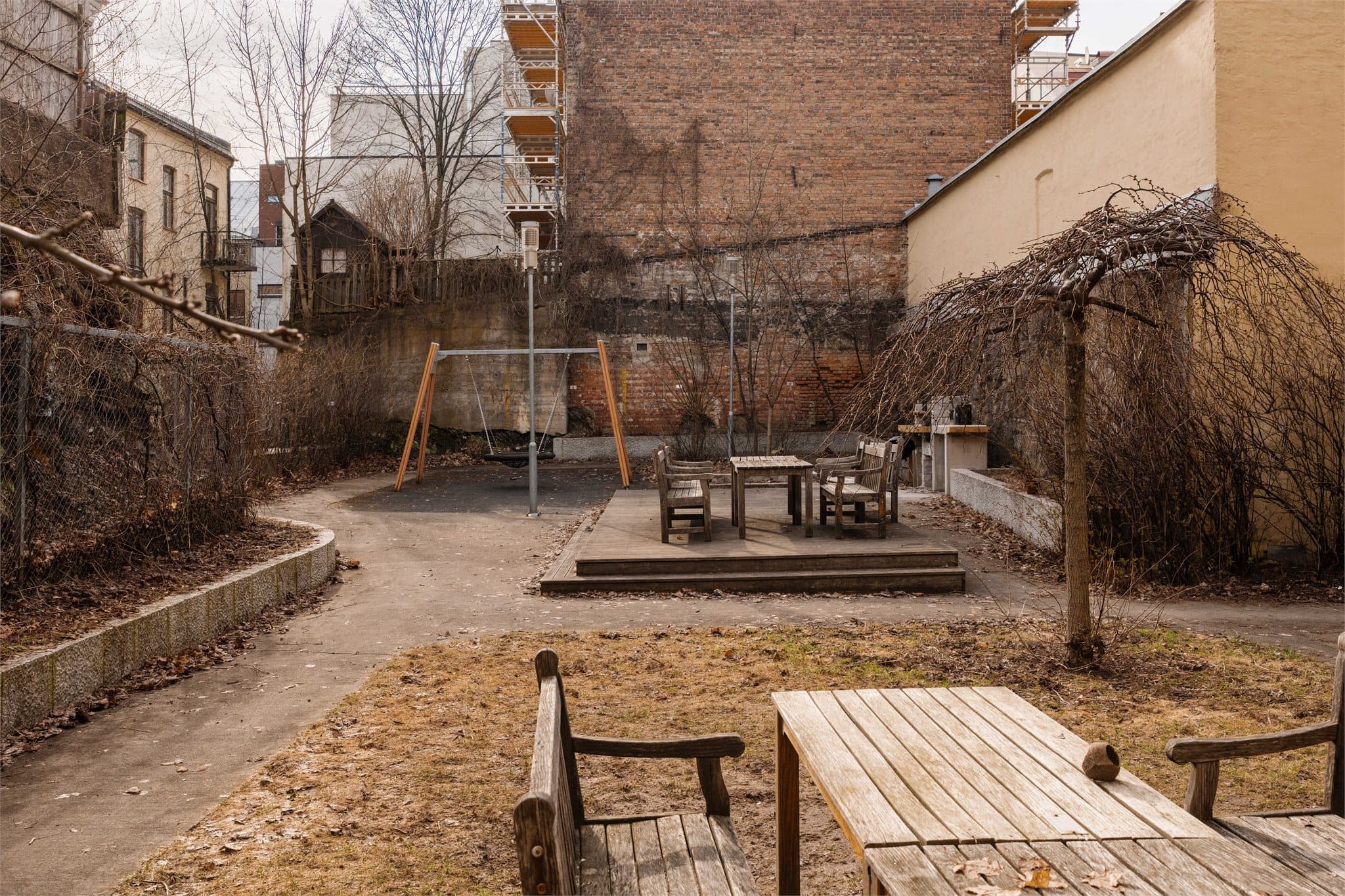 Felles uteområde med lekeplass og flere sittegrupper.