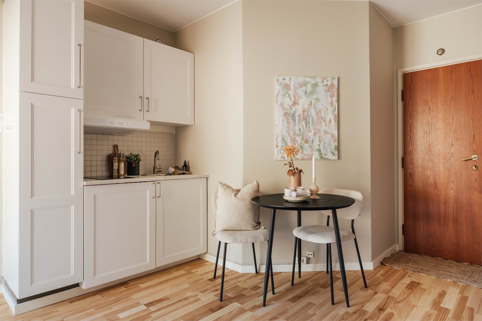 Kjøkkenet er sømløst integrert i rommet, med profilerte fronter og fliser over en praktisk arbeidsbenk.