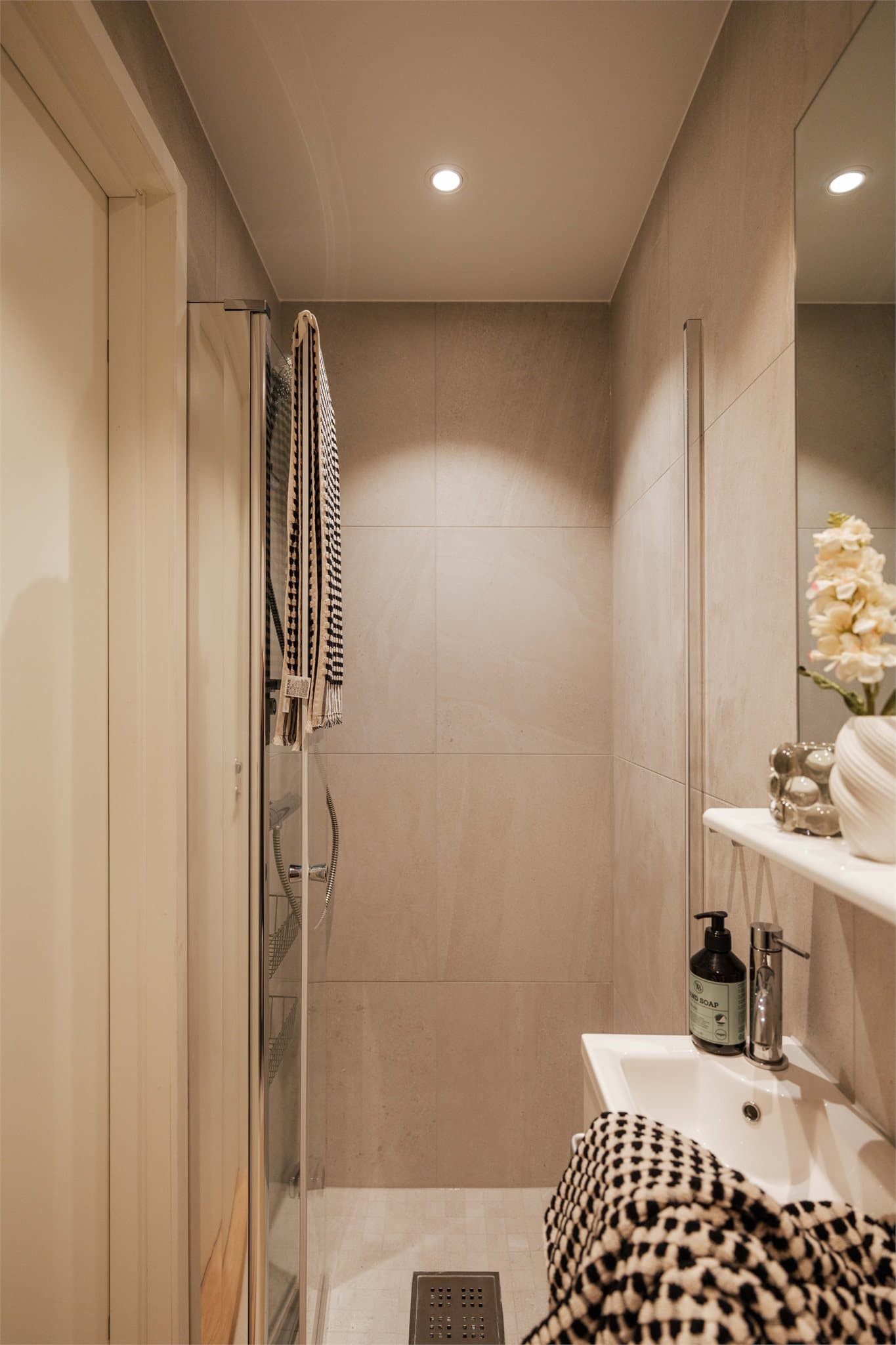 Badet er utstyrt med dusj på gulv og moderne baderomsinnredning.