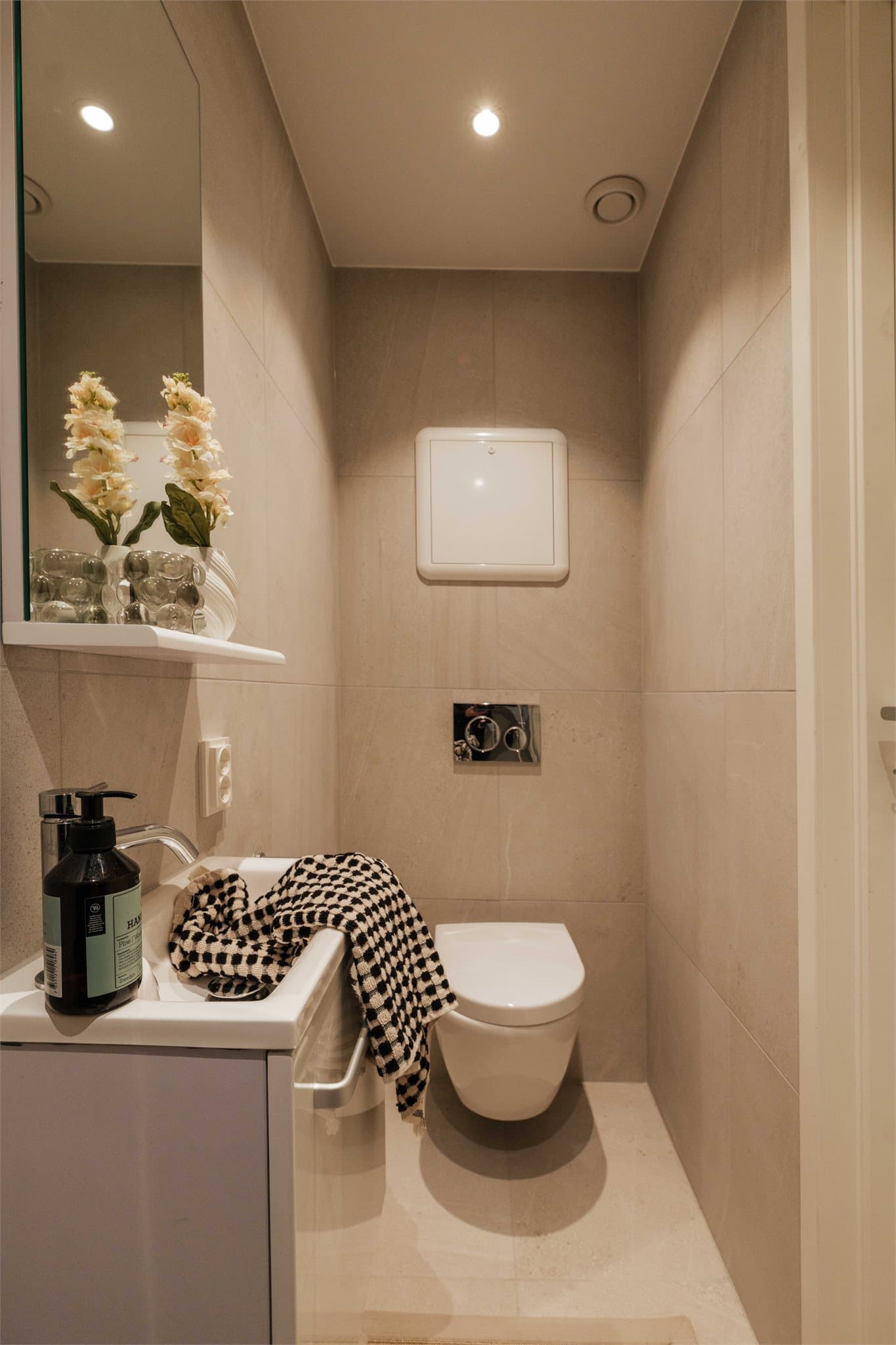 Her er det vegghengt toalett med innebygget sisterne og varmekabler i gulv.