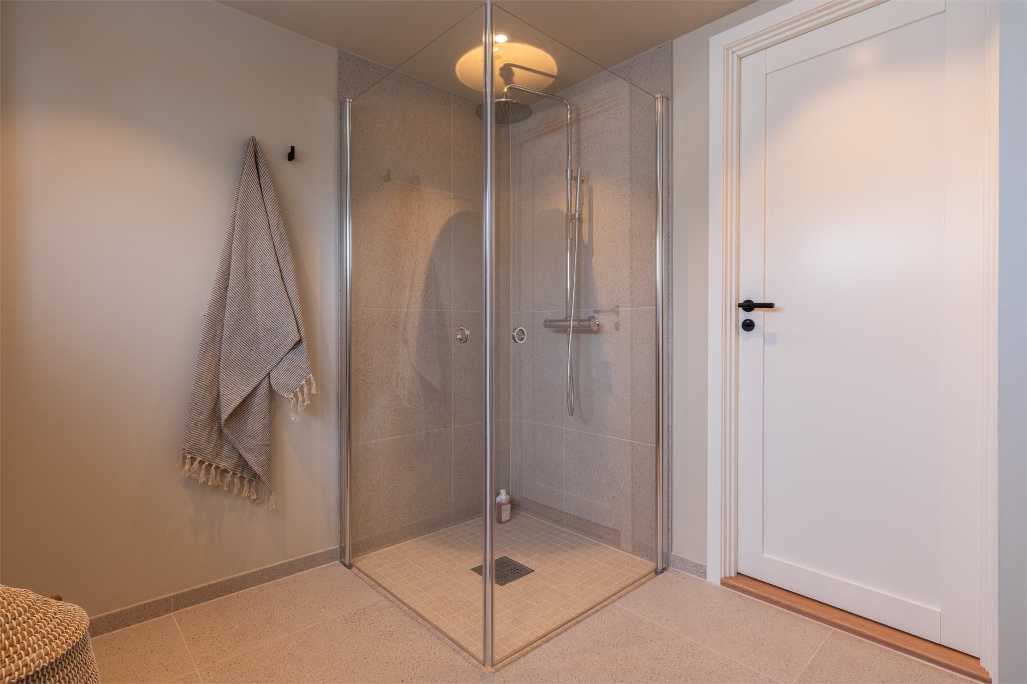 Badet er utført med storformatfliser på gulvet, gulvvarme, downlights og høytsittende vindusrekke.