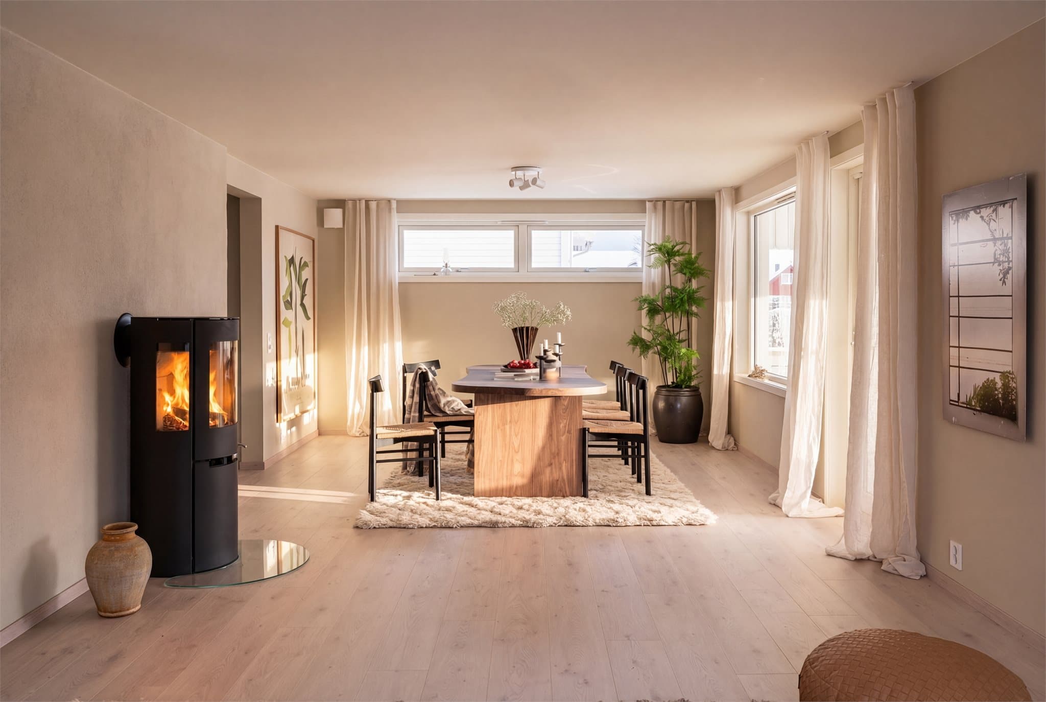 Stuen har ny peisovn med stort flammebilde, en varmepumpe og varmefolie i gulvet.