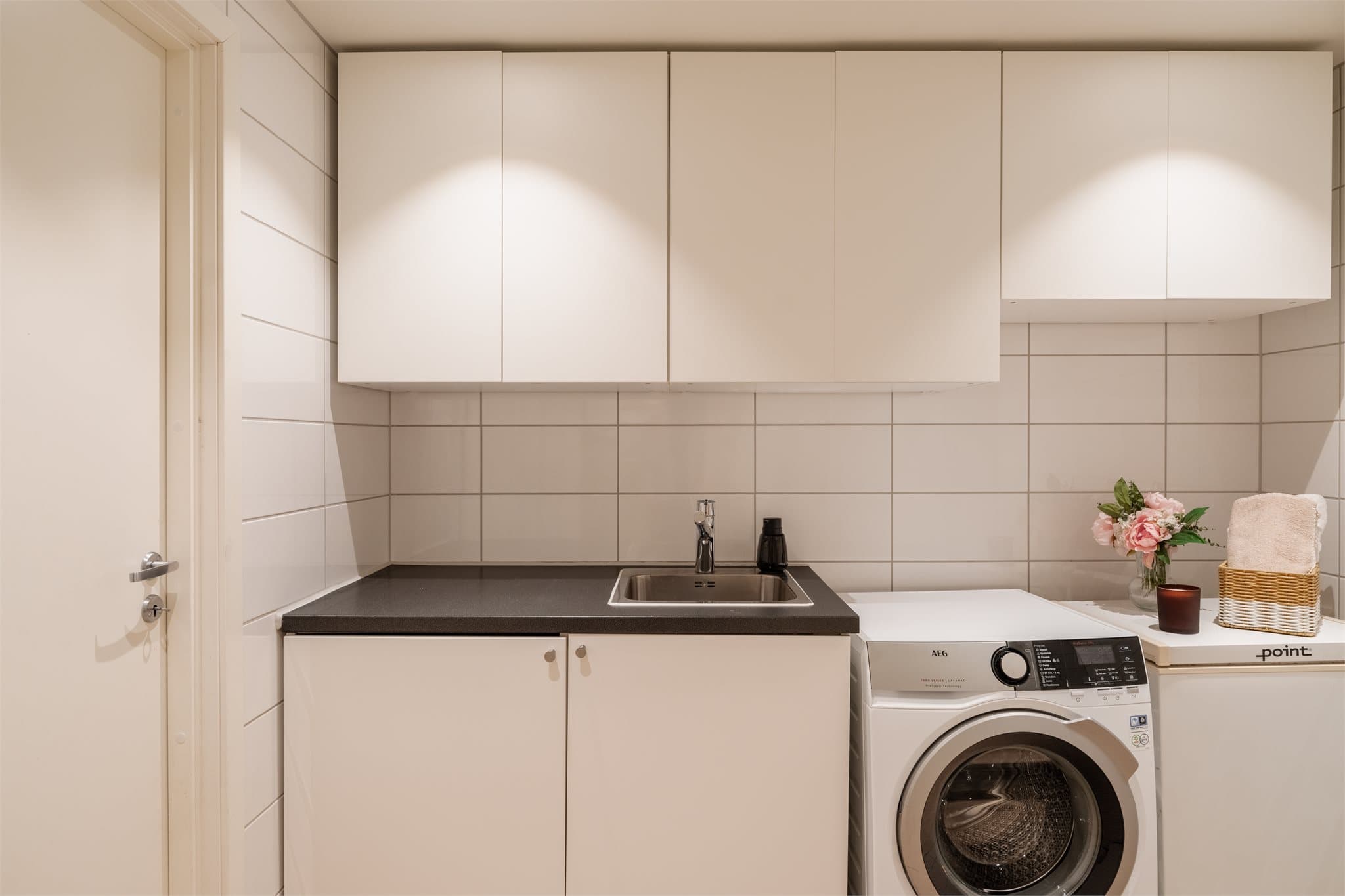 Her har du fiks ferdig opplegg for både vaskemaskin og tørketrommel, samt en dyp vaskekum og god skapplass til vaskemidler.