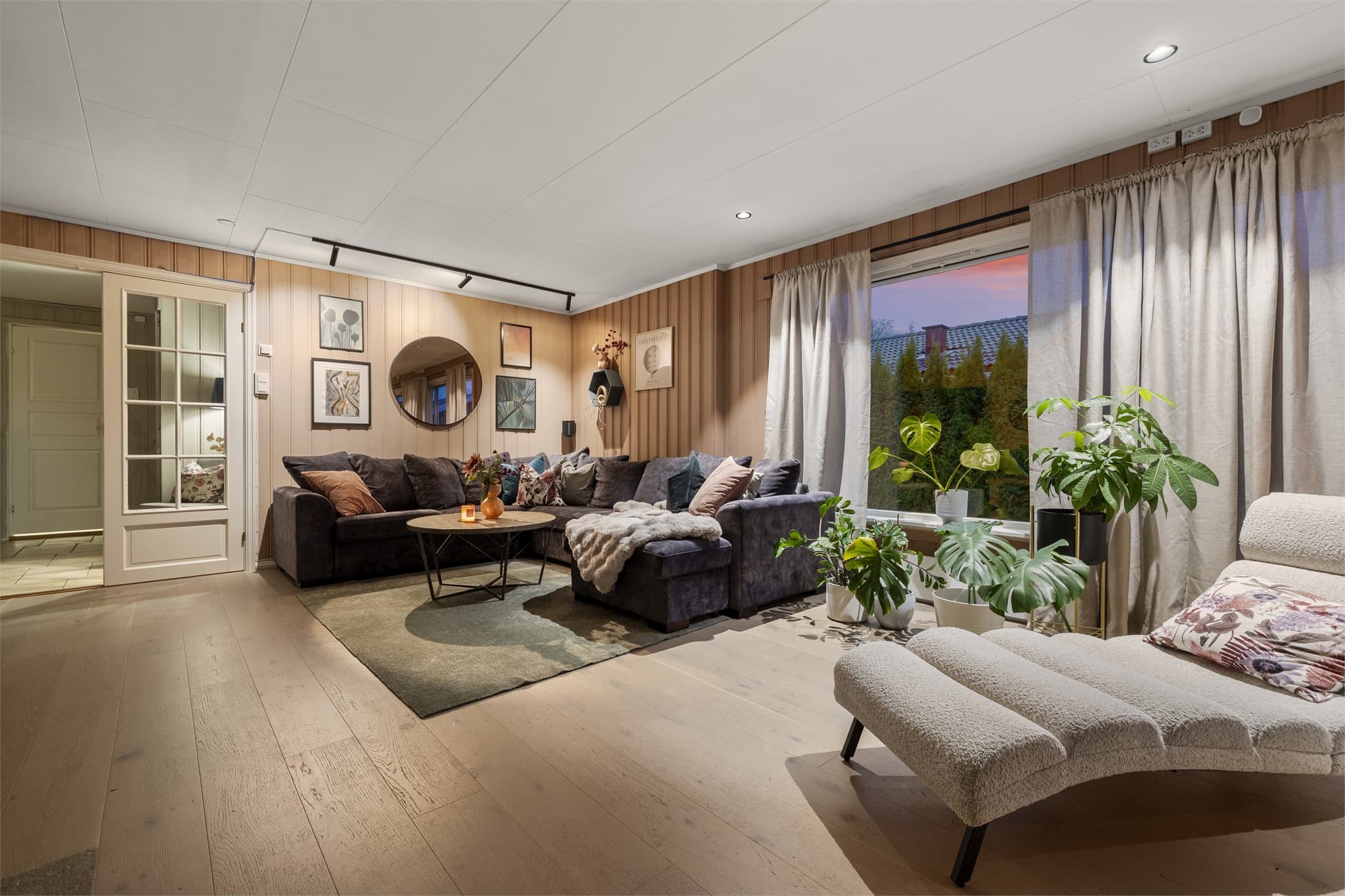 Stuen er lys og luftig og har plass til ulike sofaløsninger med tilhørende møblement.