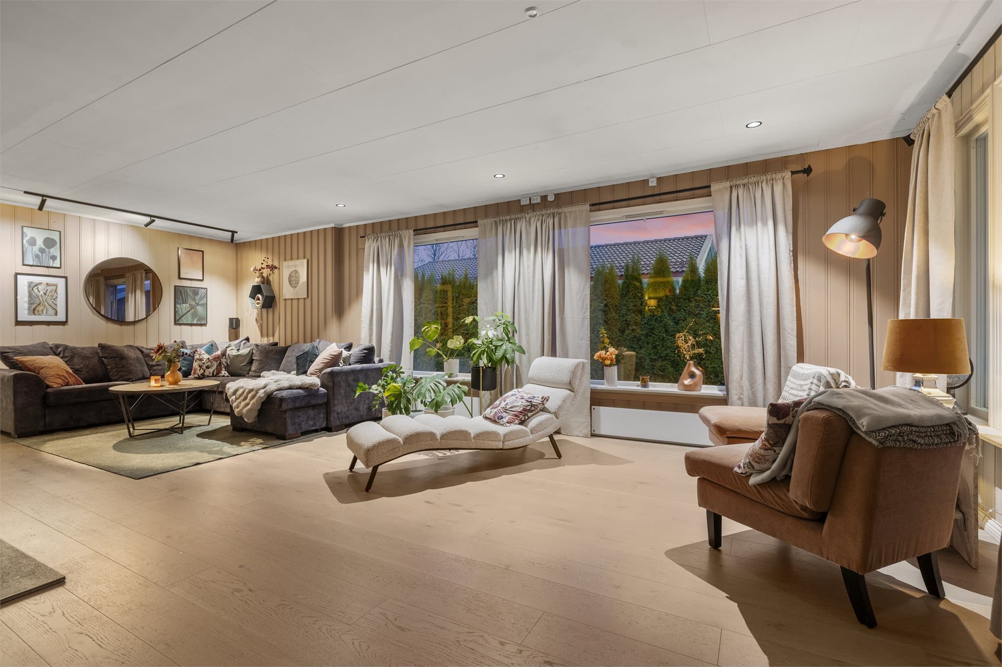 Lys og romslig stue med store vindusflater