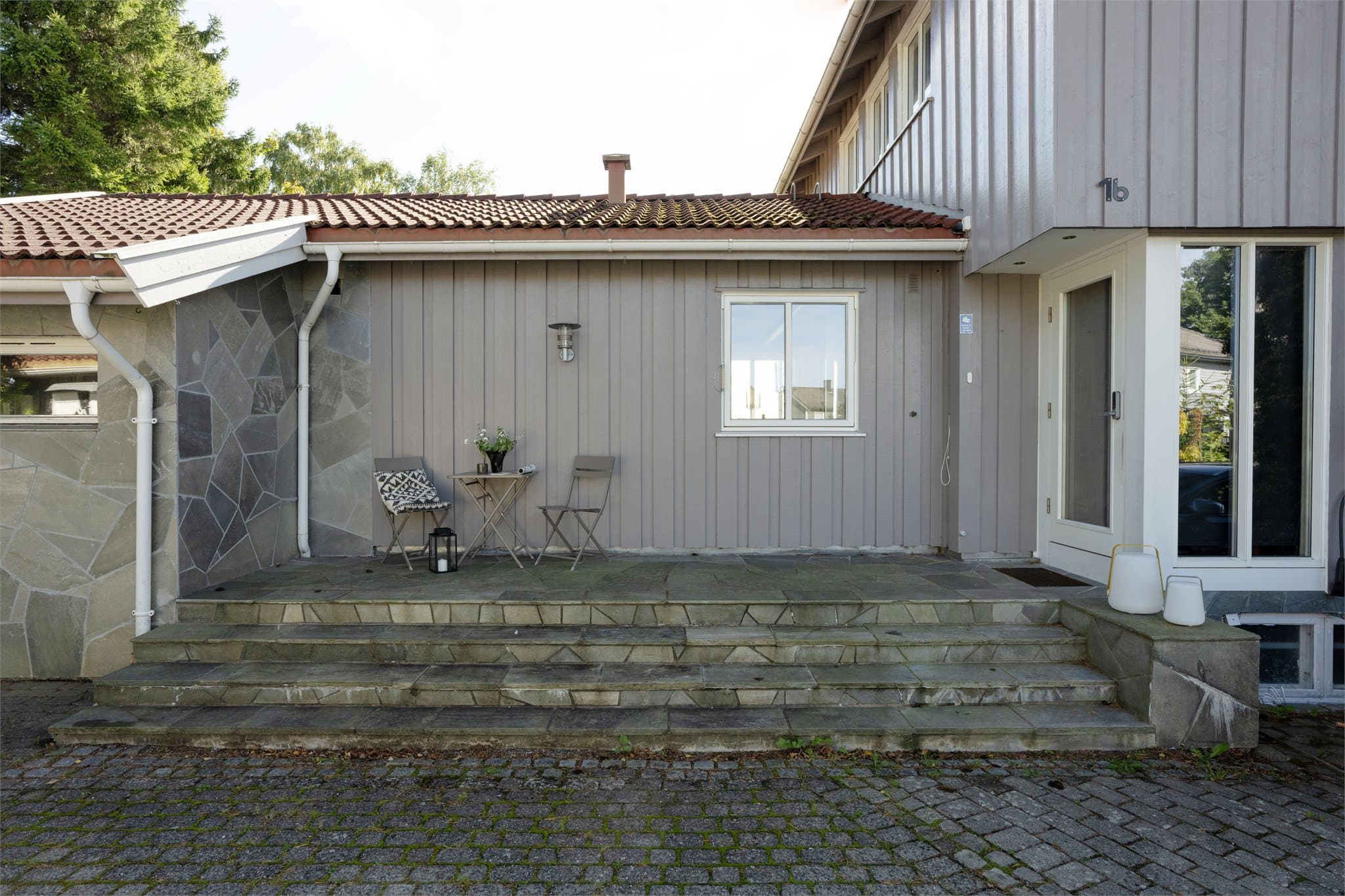 Inngangsparti tekket med skiferheller og overbygget takareal.