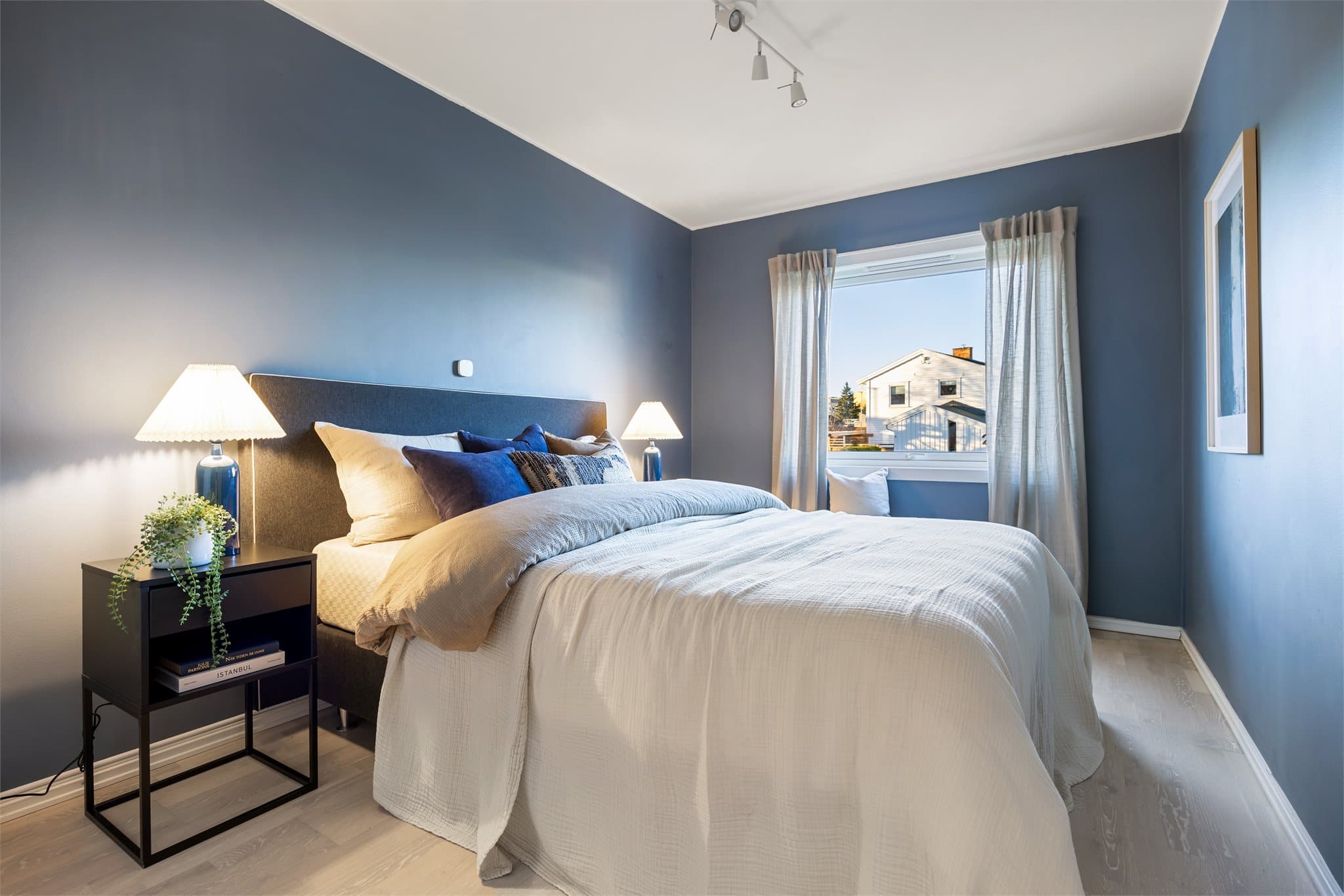 Delikat og romslig soverom med plass til dobbeltseng og tilhørende møblement.