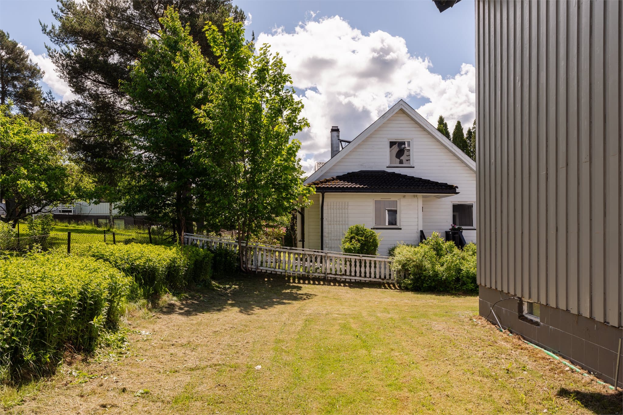 Hagen er opparbeidet med gressplen og beplantning.