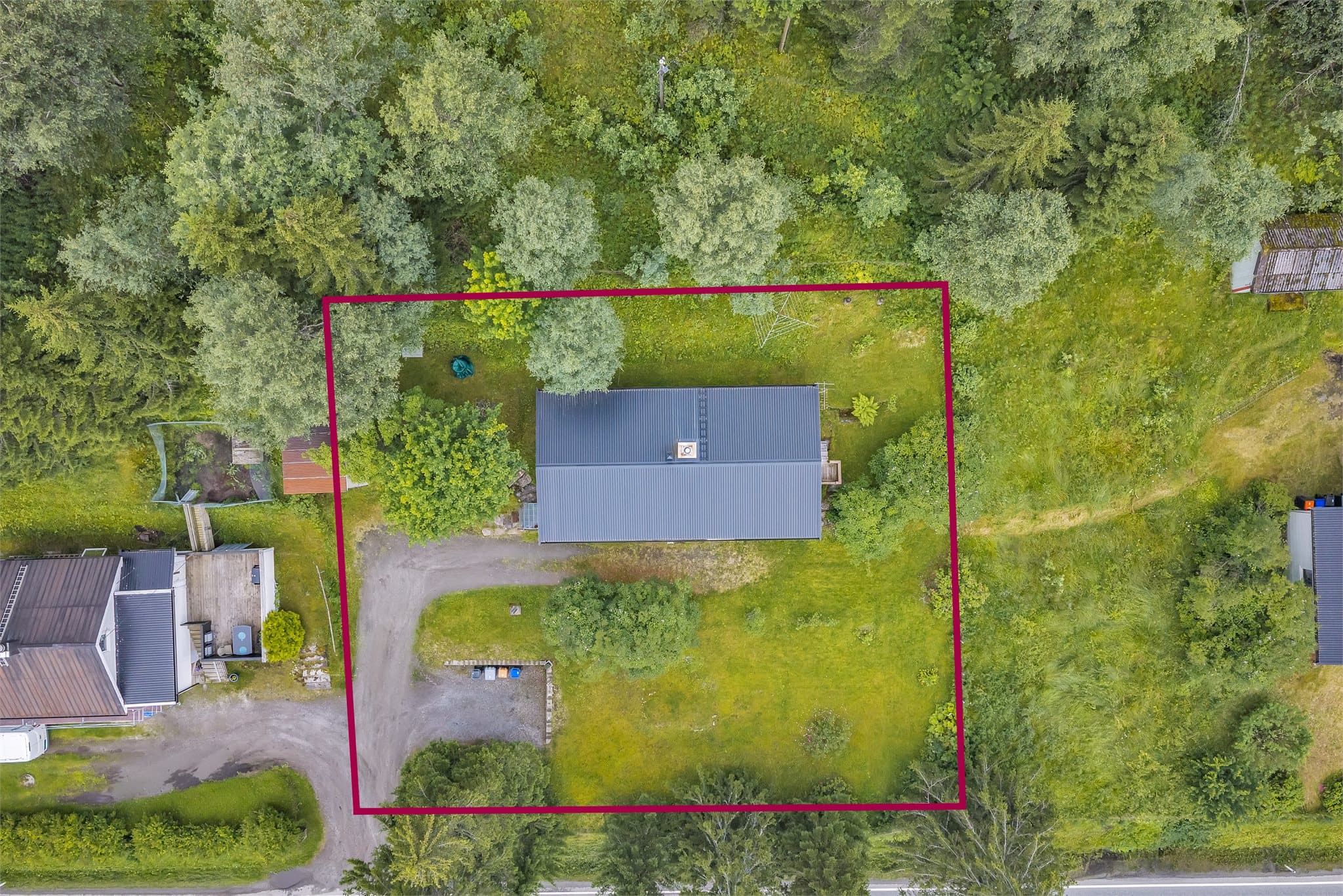 Eiendommen ligger på en romslig tomt med plen, beplantning og skogsområder som nærmeste nabo