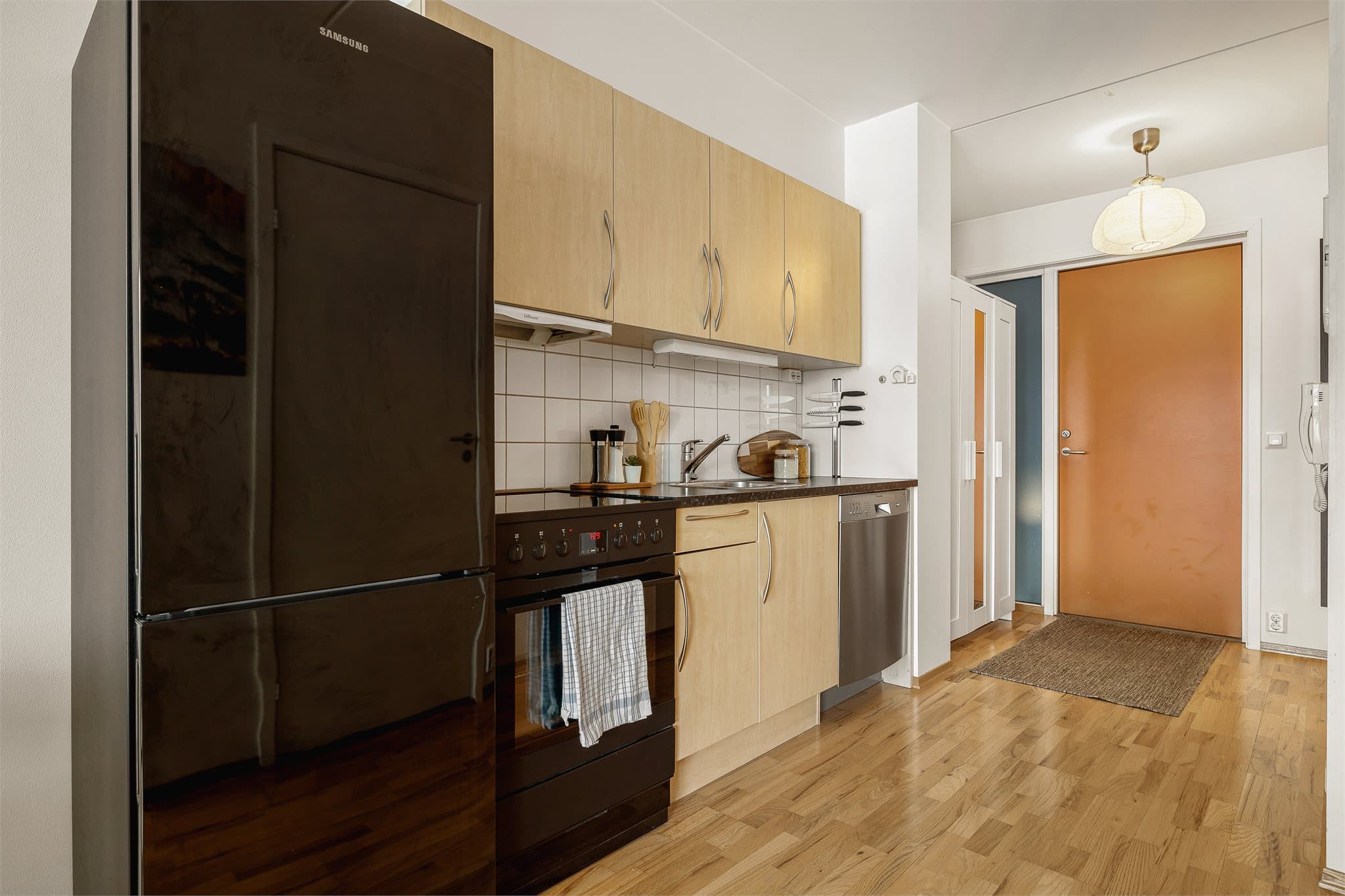 Tidløst kjøkken med trefargede, slette fronter og en praktisk laminatbenkeplate.