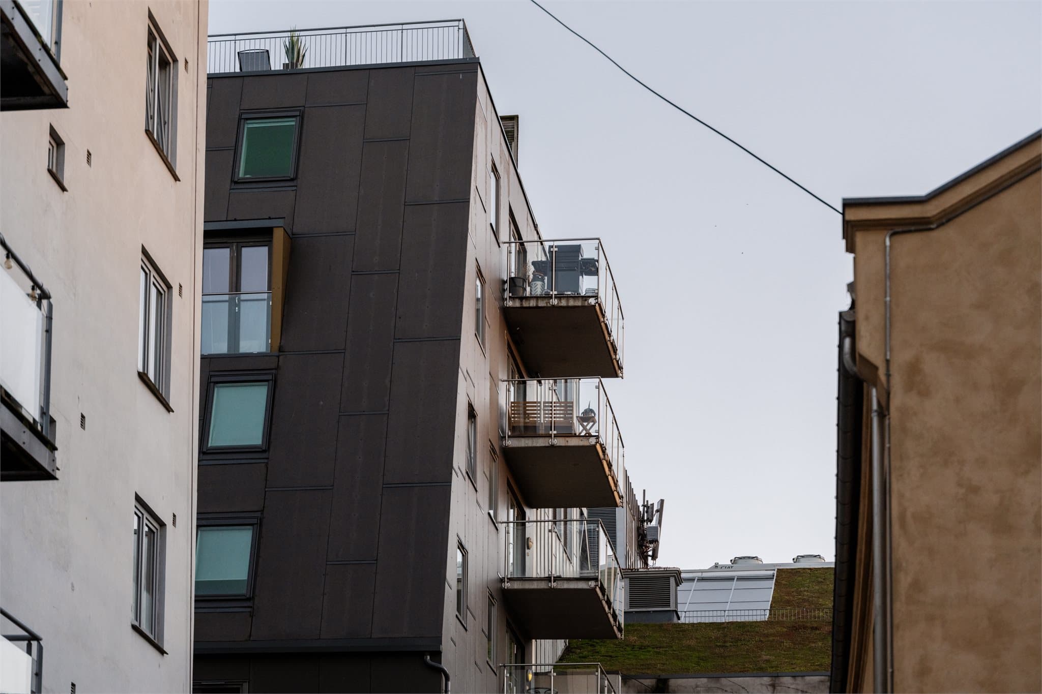 Bygget fra 2012 har moderne arkitektur med mørke fasadeplater og markante balkonger.