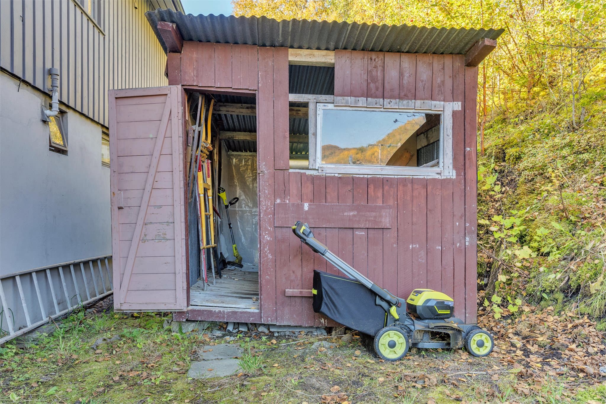 Frittstående vedskur plassert på baksiden av boligen.