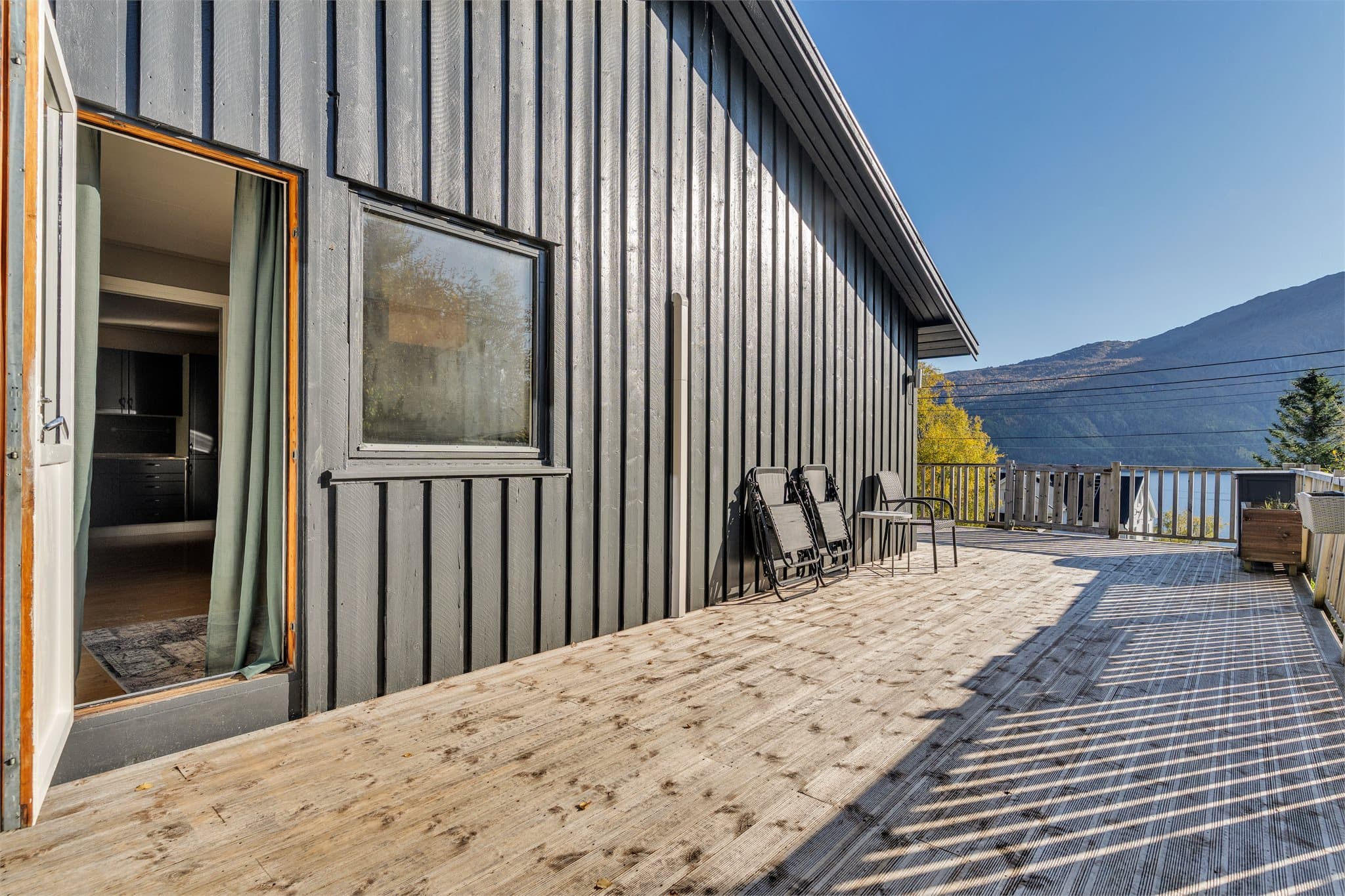 Verandadør i malt treverk og glassfelt gir enkel adkomst mellom inne og ute.