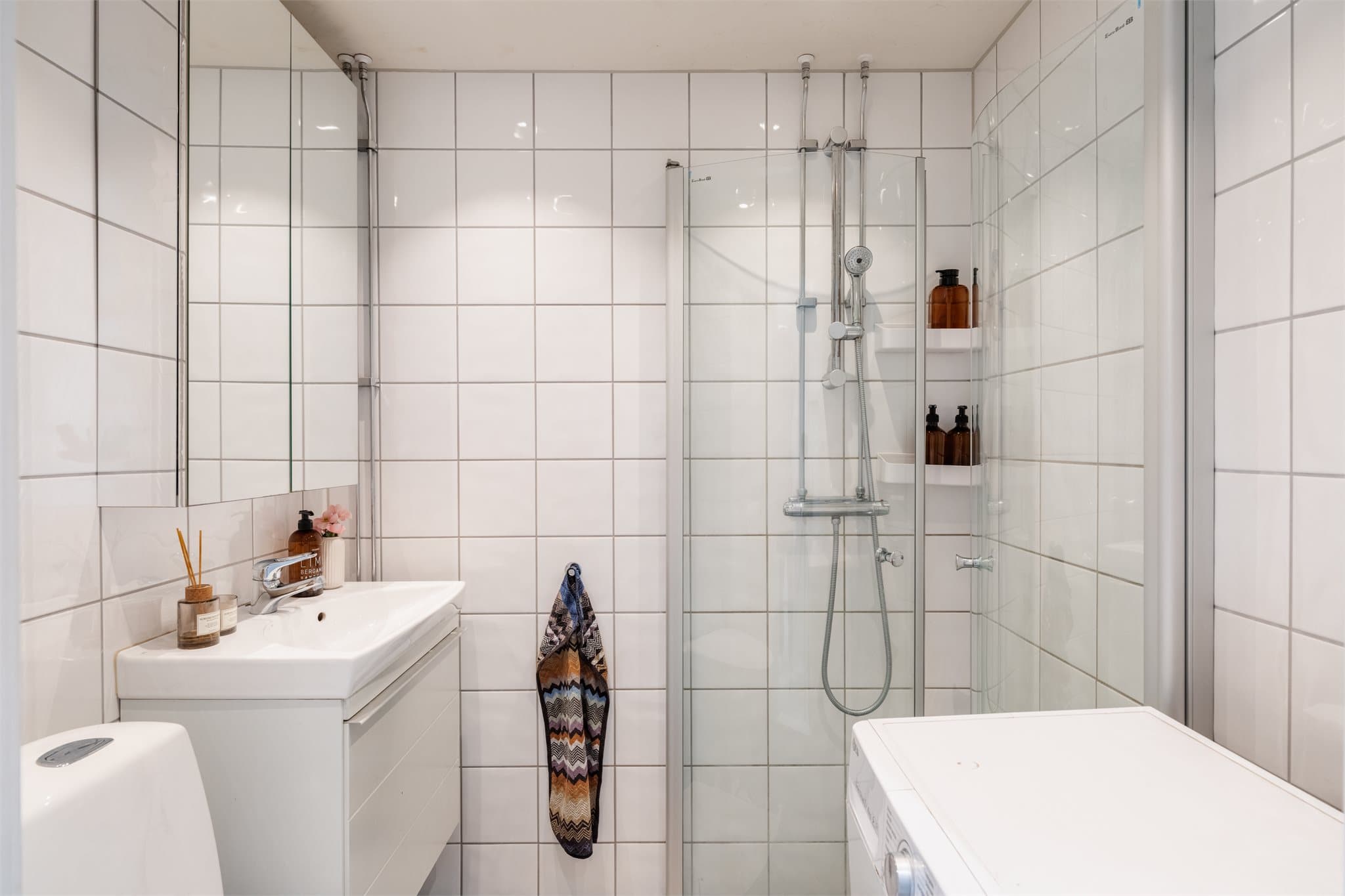 Badet er innredet med klosett, servant nedfelt i innredning, speilskap og dusjhjørne med svingbare glassdører. Opplegg for vaskemaskin på badet, i tillegg til fellesvaskeri i kjeller.