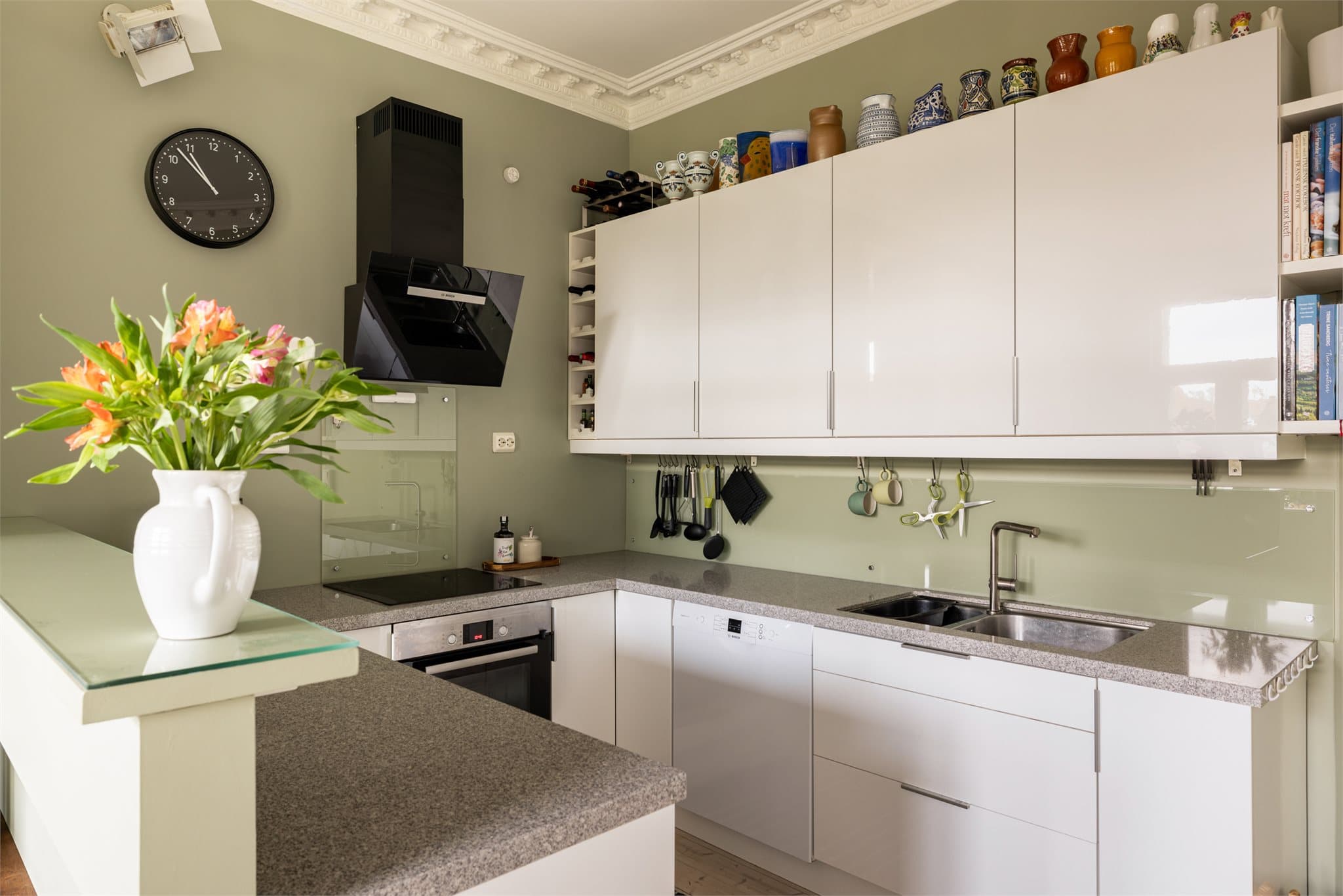 Kjøkkeninnredning fra IKEA. Innredningen har glatte, høyglans fronter, og benkeplaten i stein med nedfelt stålkum gir et stilrent uttrykk.