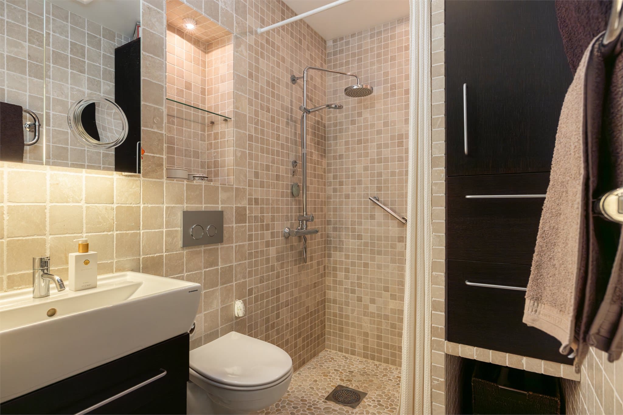 Badet er gjennomført i tidløse materialer og har en funksjonell løsning for daglig bruk.