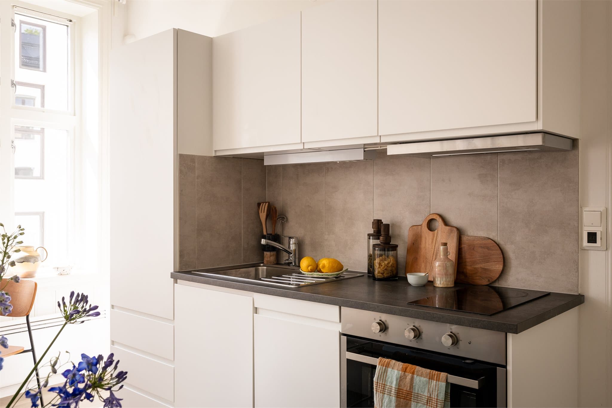 Kjøkkenet har lyse slette fronter og laminat benkeplate. Det er god skapplass til størrelsen å være.