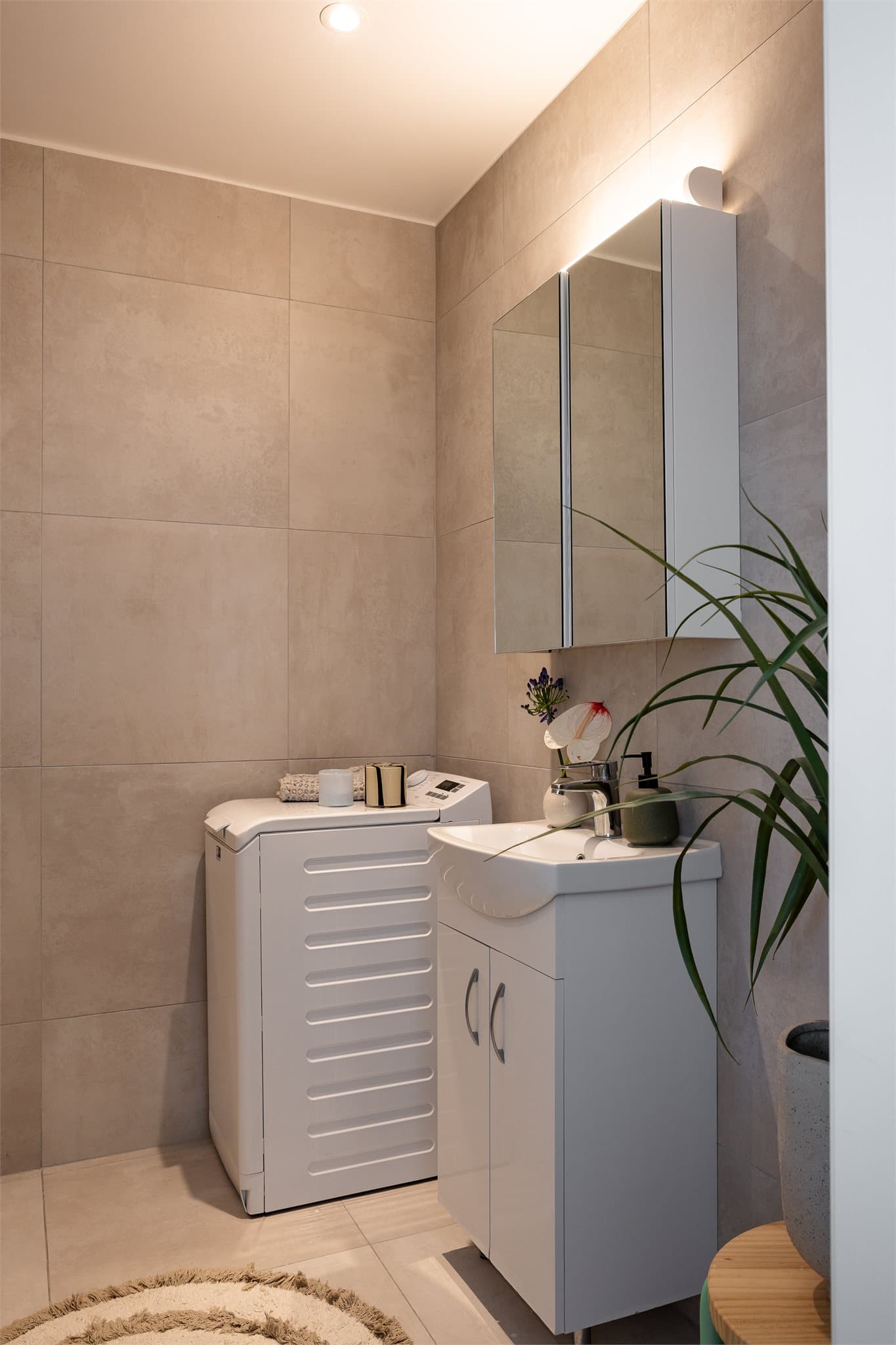 Et flislagt baderom som ble overflateoppusset i 2022 og har opplegg for vaskemaskin, varmekabler på gulv og downlights i tak.