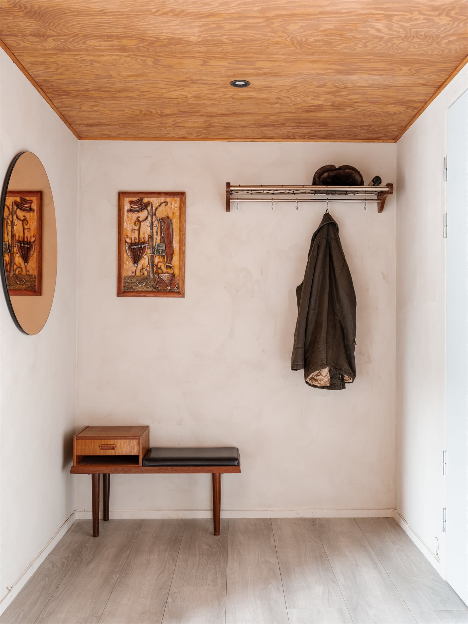 Praktisk løsning med knagger og sittebenk gir en funksjonell hverdag. Gangen har et lunt preg med gjennomgående materialvalg og gir et hyggelig førsteinntrykk av boligen.