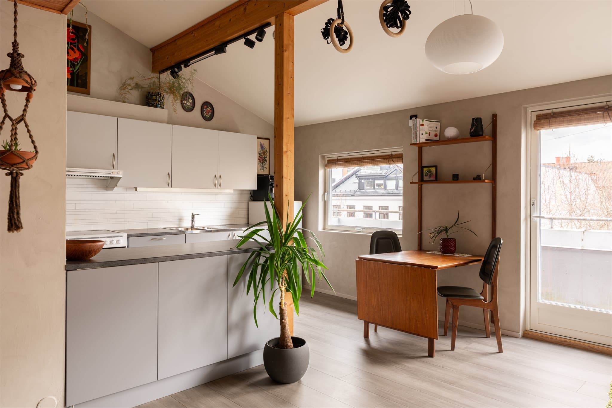 Generøs takhøyde og synlige takbjelker gir rommet karakter.