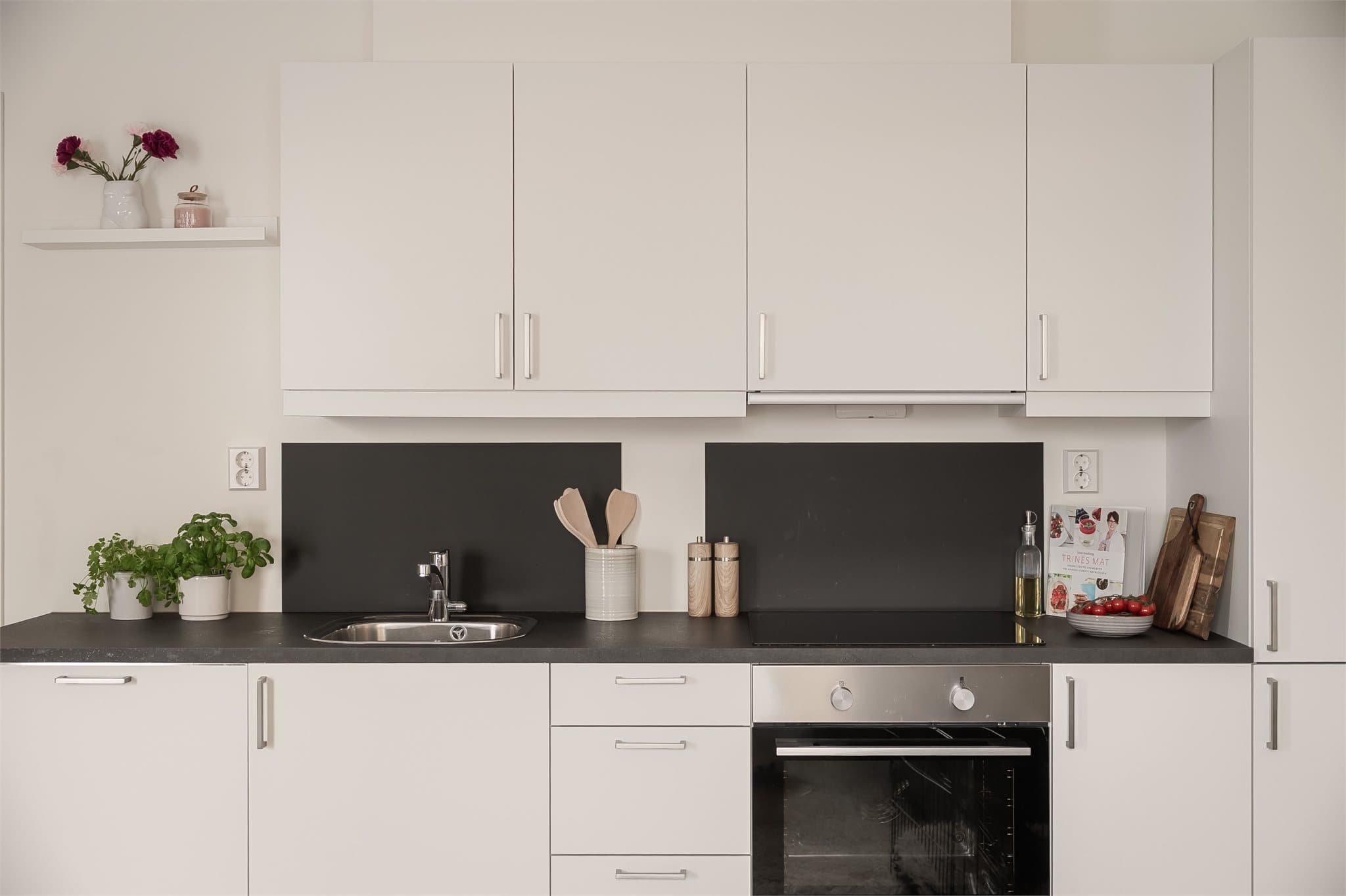 Moderne og tidløst kjøkken med integrerte hvitevarer.