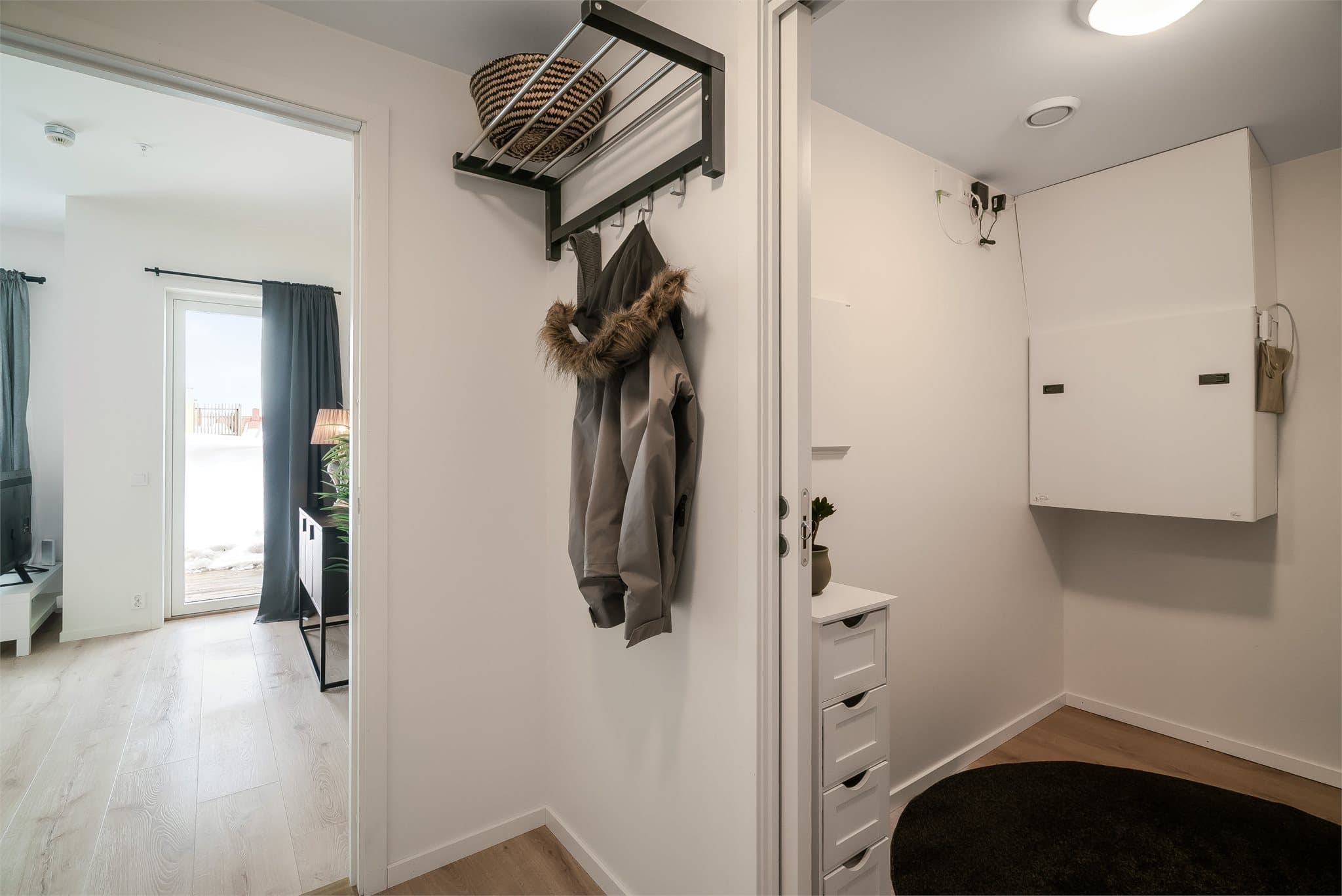 Praktisk entré med oppheng for yttertøy og tilknyttet innvendig bod som gir gode oppbevaringsmuligheter.