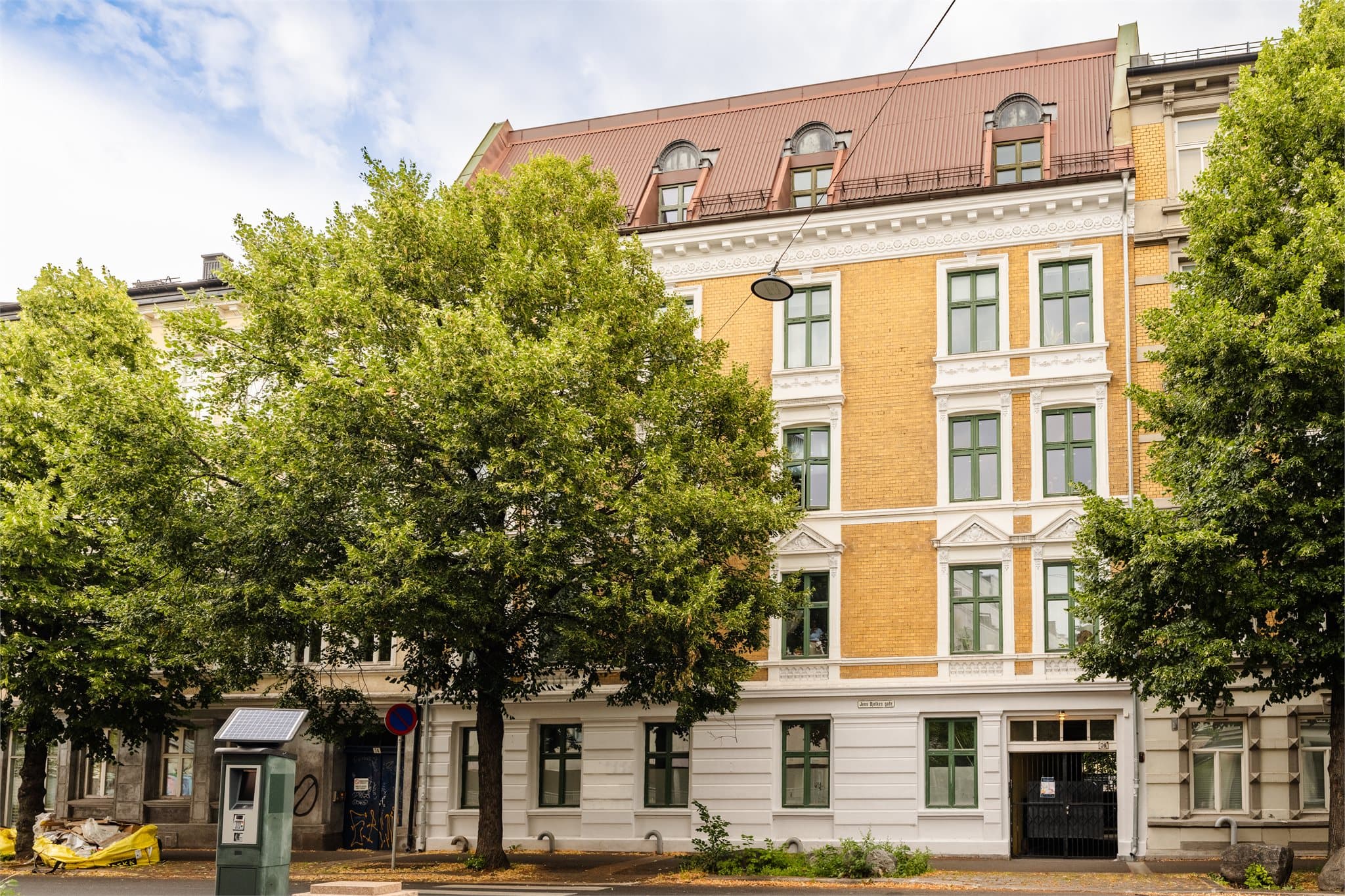 Bygården har en karakteristisk fasade med teglstein og pussede detaljer.