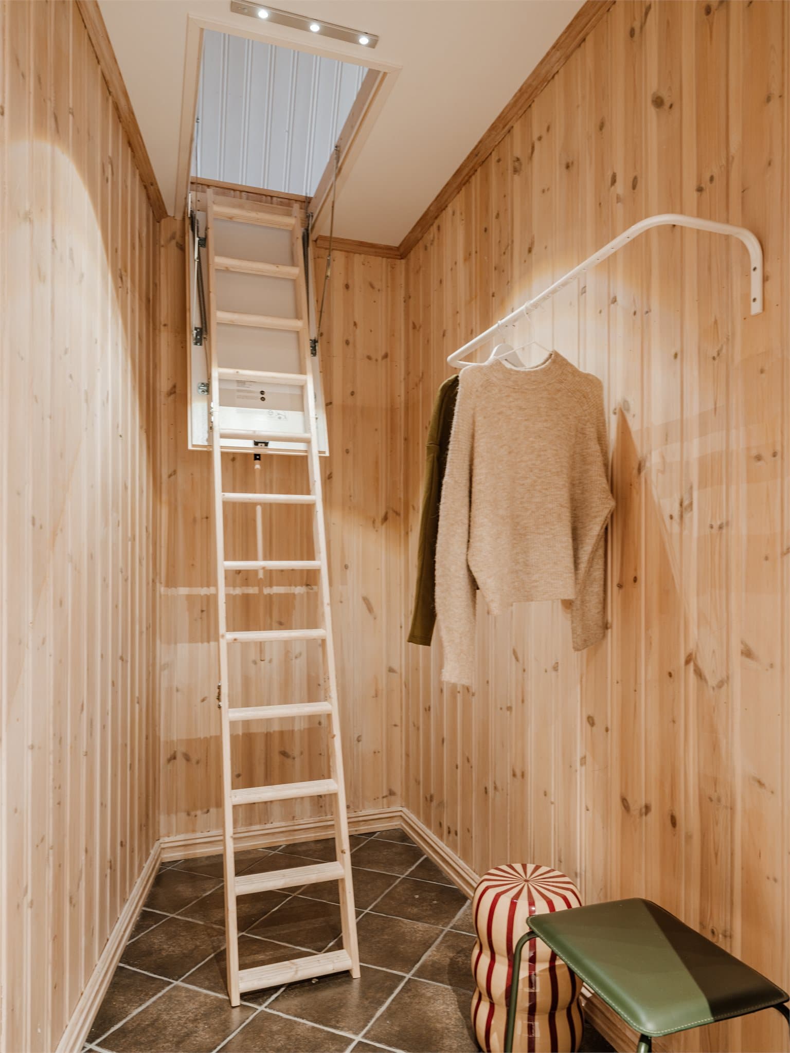 Rommet med loftstrappen fungerer også som en praktisk garderobe.