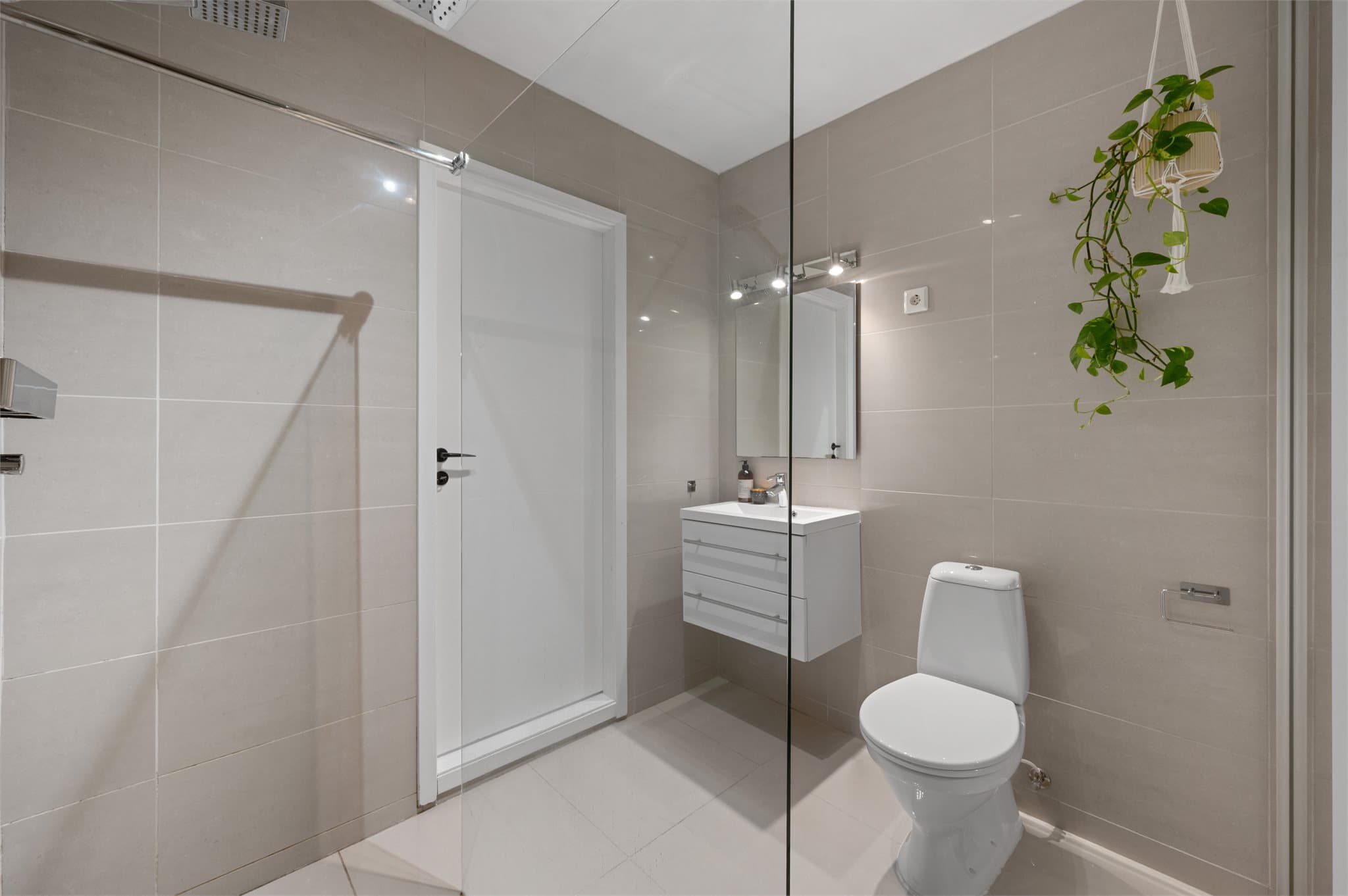 - Badet er innredet med heldekkende servant, toalett, dusjvegg i glass og varmtvannsbereder -