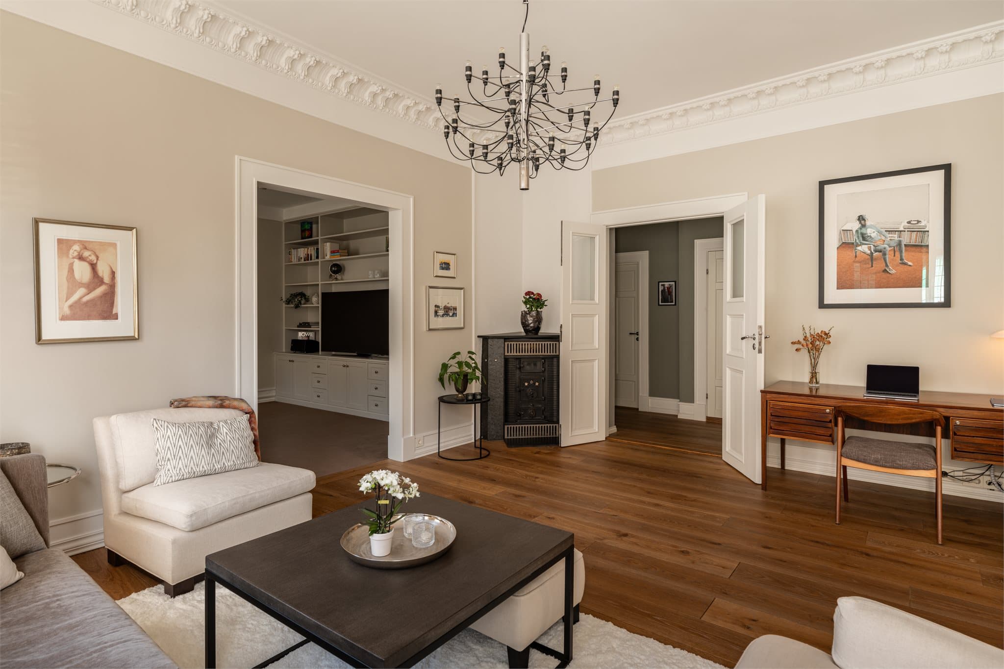 Hovedstuen preges av store, klassiske vinduer som slipper inn rikelig med lys, en elegant kamin og en imponerende takhøyde på hele 3,25 meter.