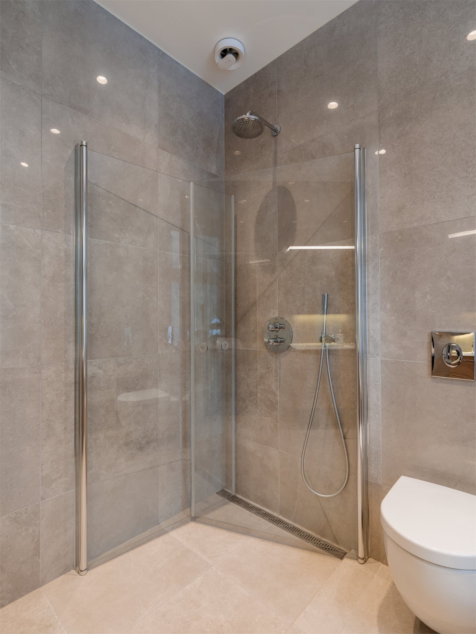 I tillegg til badekaret har hovedbadet også et separat dusjhjørne med svingbare glassdører.