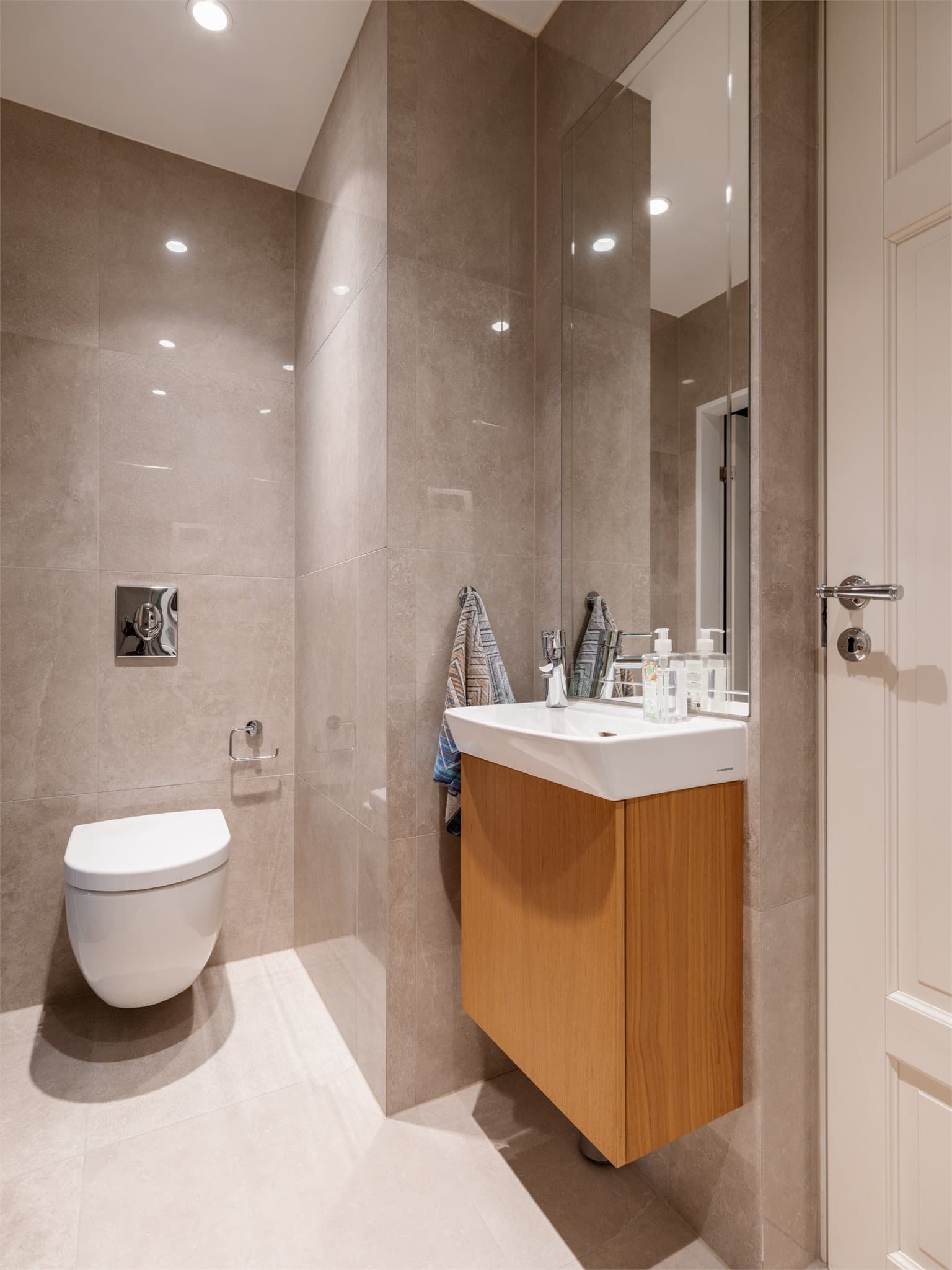 Det andre badet har dusjhjørne, vegghengt toalett, slett servantinnredning og opplegg for vaskemaskin og tørketrommel.