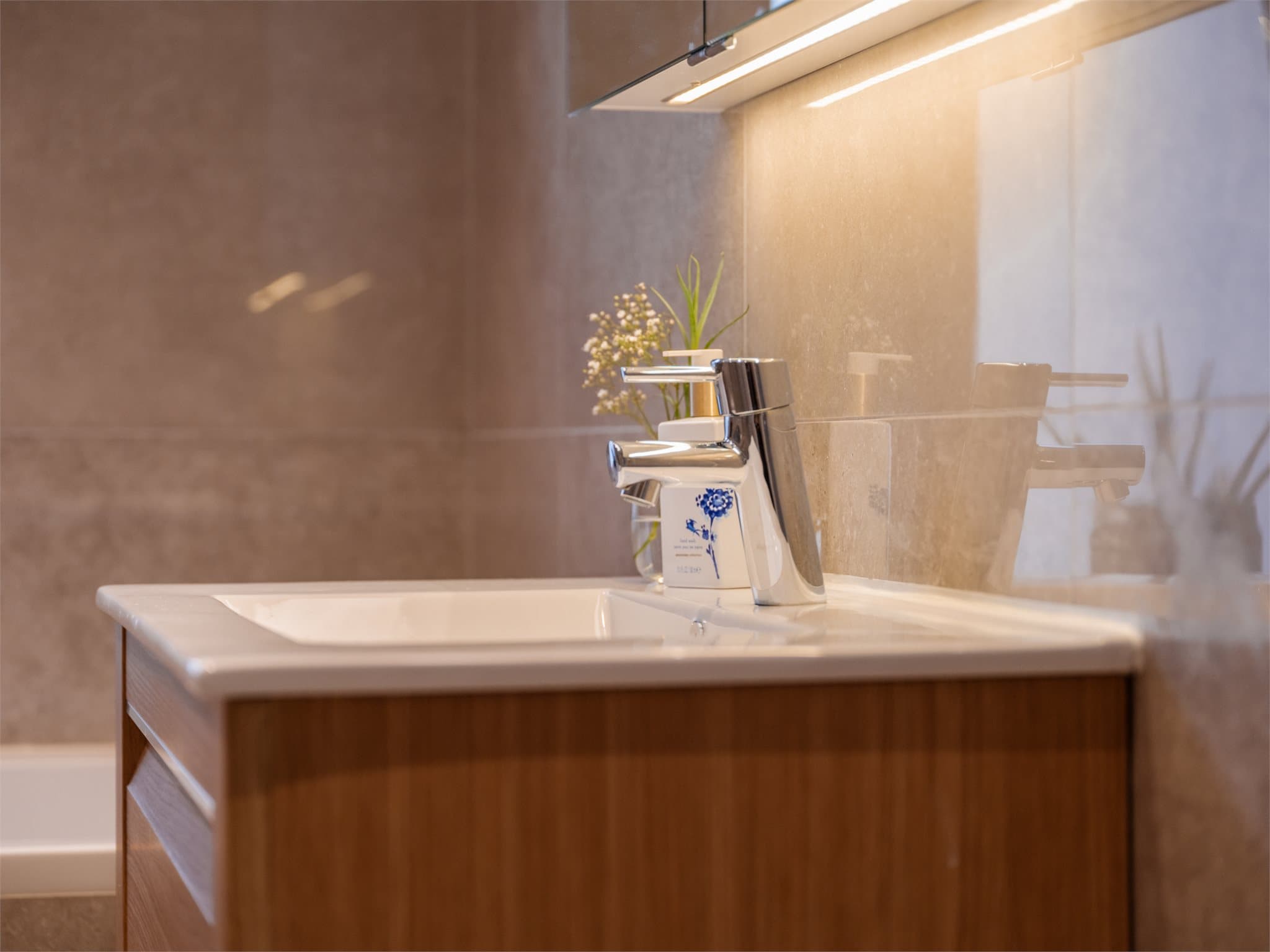 Badet har også eget vegghengt toalett og en profilert servantinnredning.