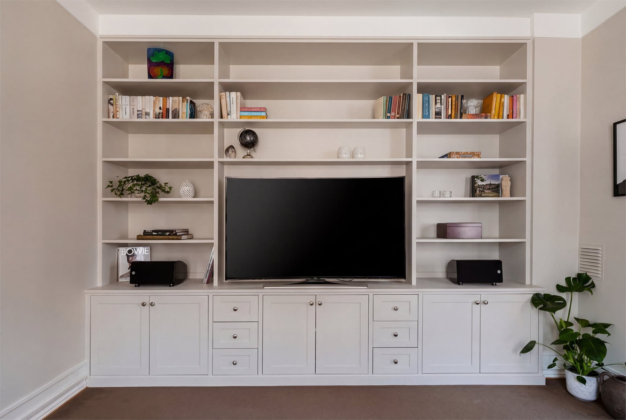 Rommet kompletteres av en smakfull, plassbygget reolløsning med integrert og diskret TV-møblement.