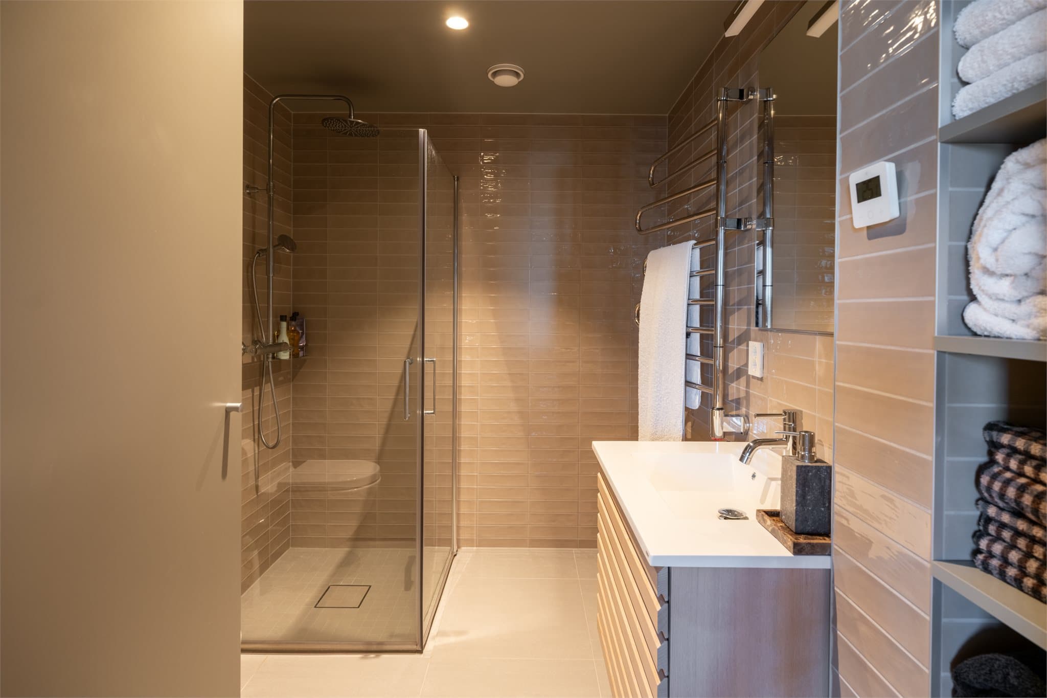 Moderne baderomsinnredning med god oppbevaringsplass og en praktisk håndkletørker.