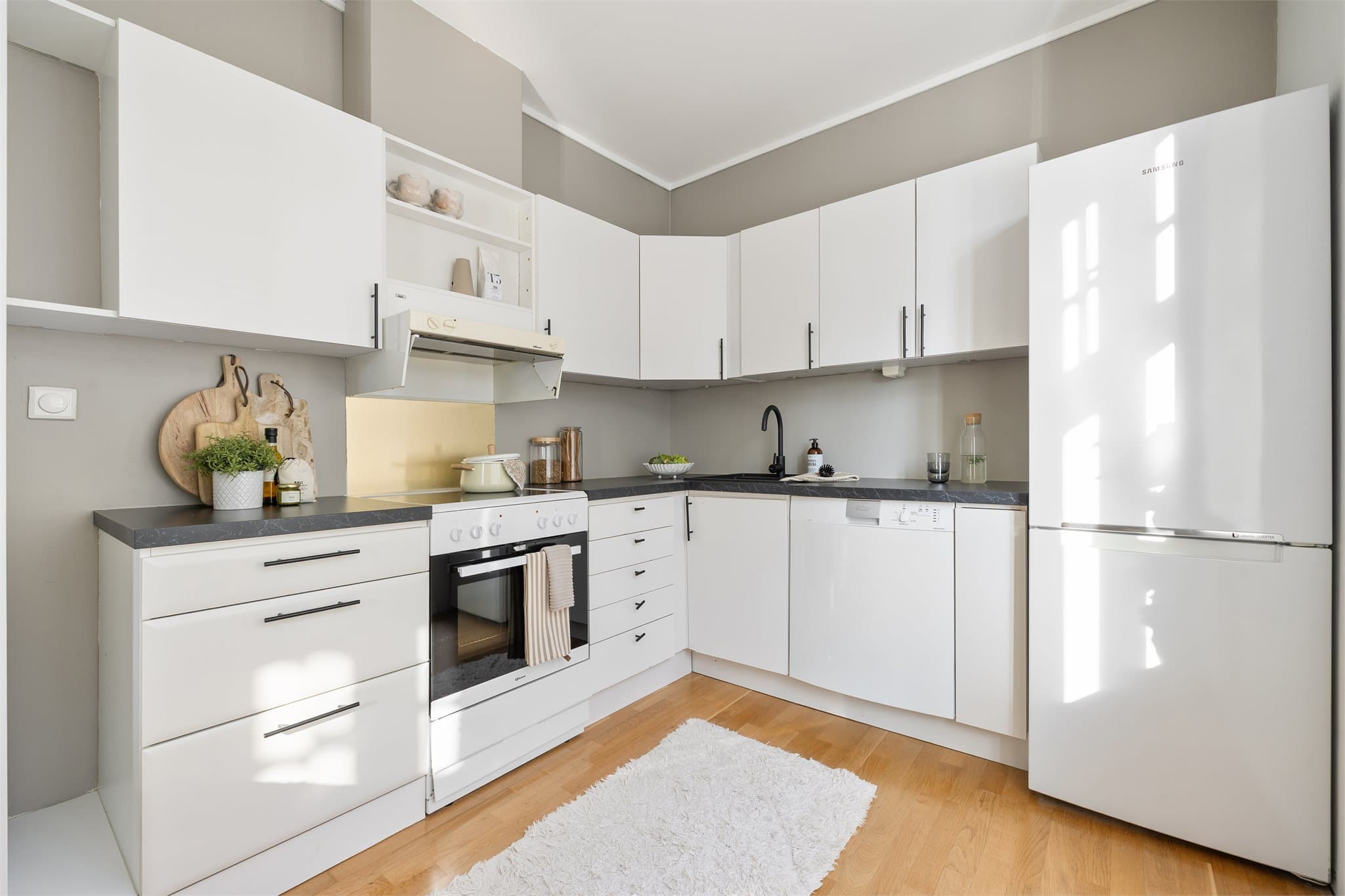 Kjøkkenet er lyst og tidløst og har godt med skapplass.