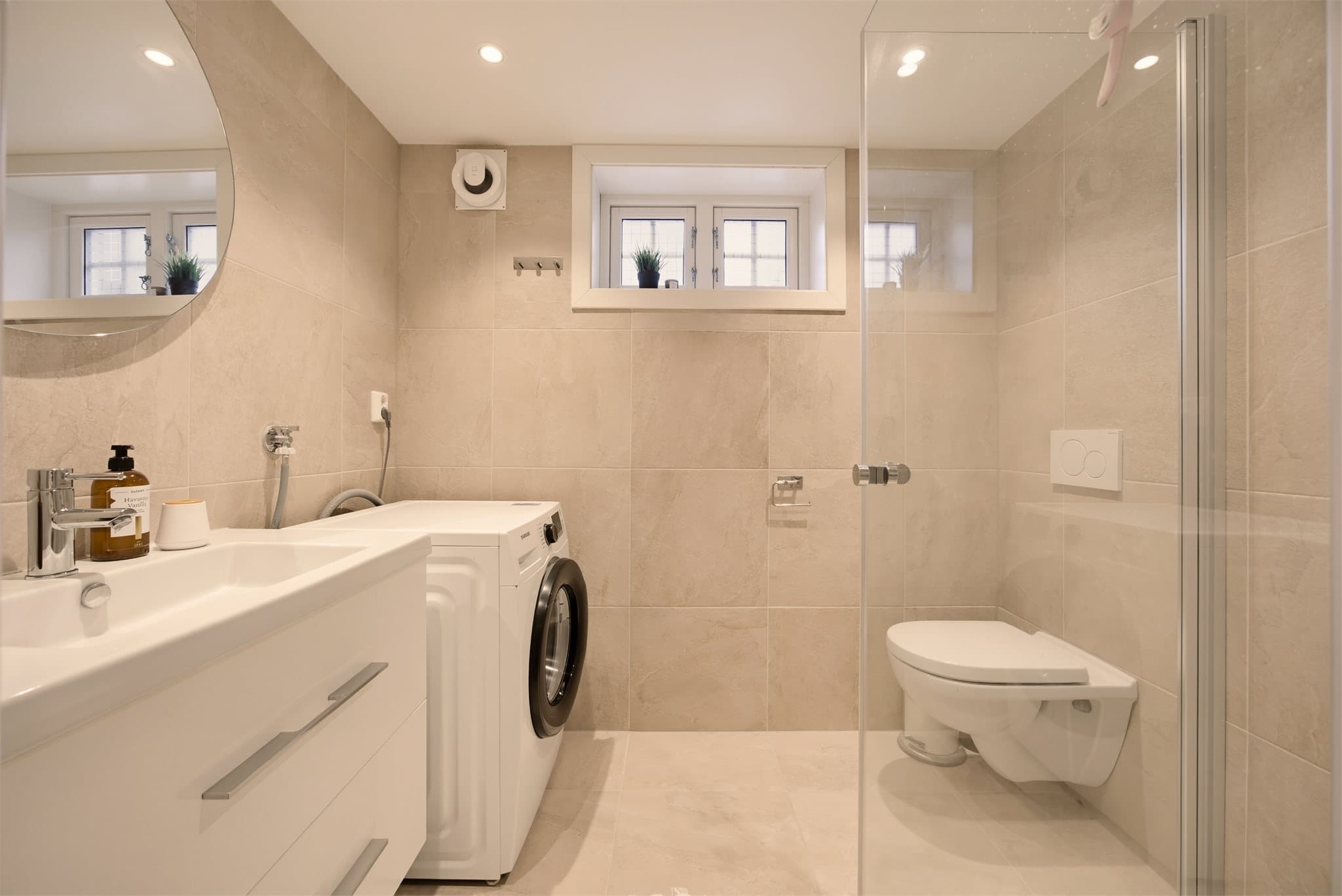 Innredet rom/bad: Lekkert flislagt bad med vannbåren gulvvarme og downlights i himling. Badet er innredet med vegghengt klosett, servant på innredning og dusjhjørne med svingbare dører.