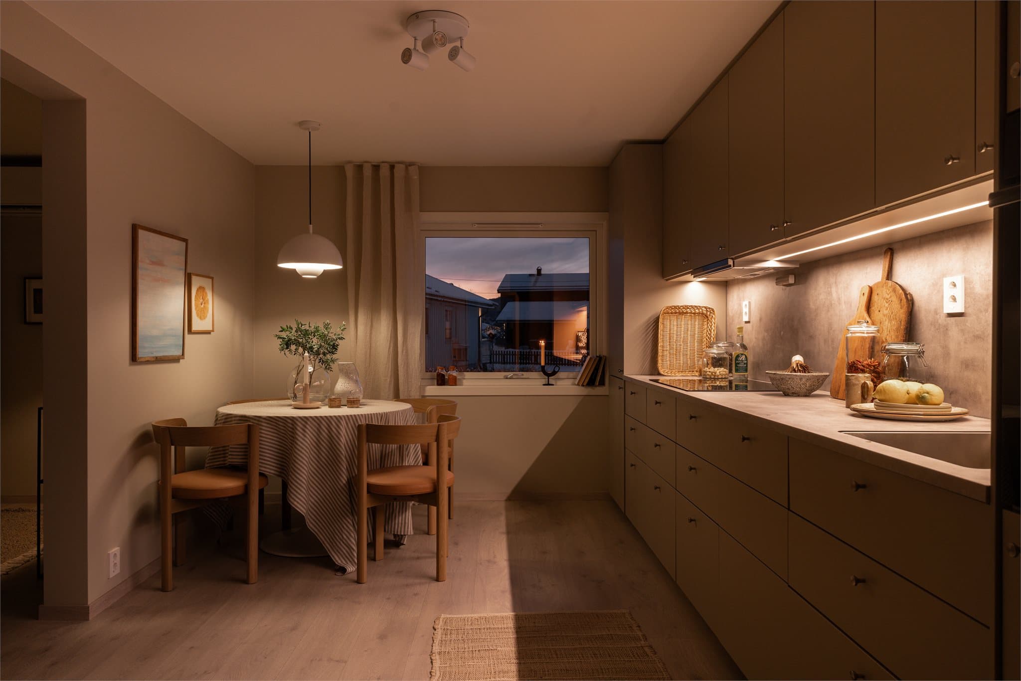 Kjøkkenet har benkeplate i laminat med underlimt vaskekum, matchende backsplash og god benkebelysning.