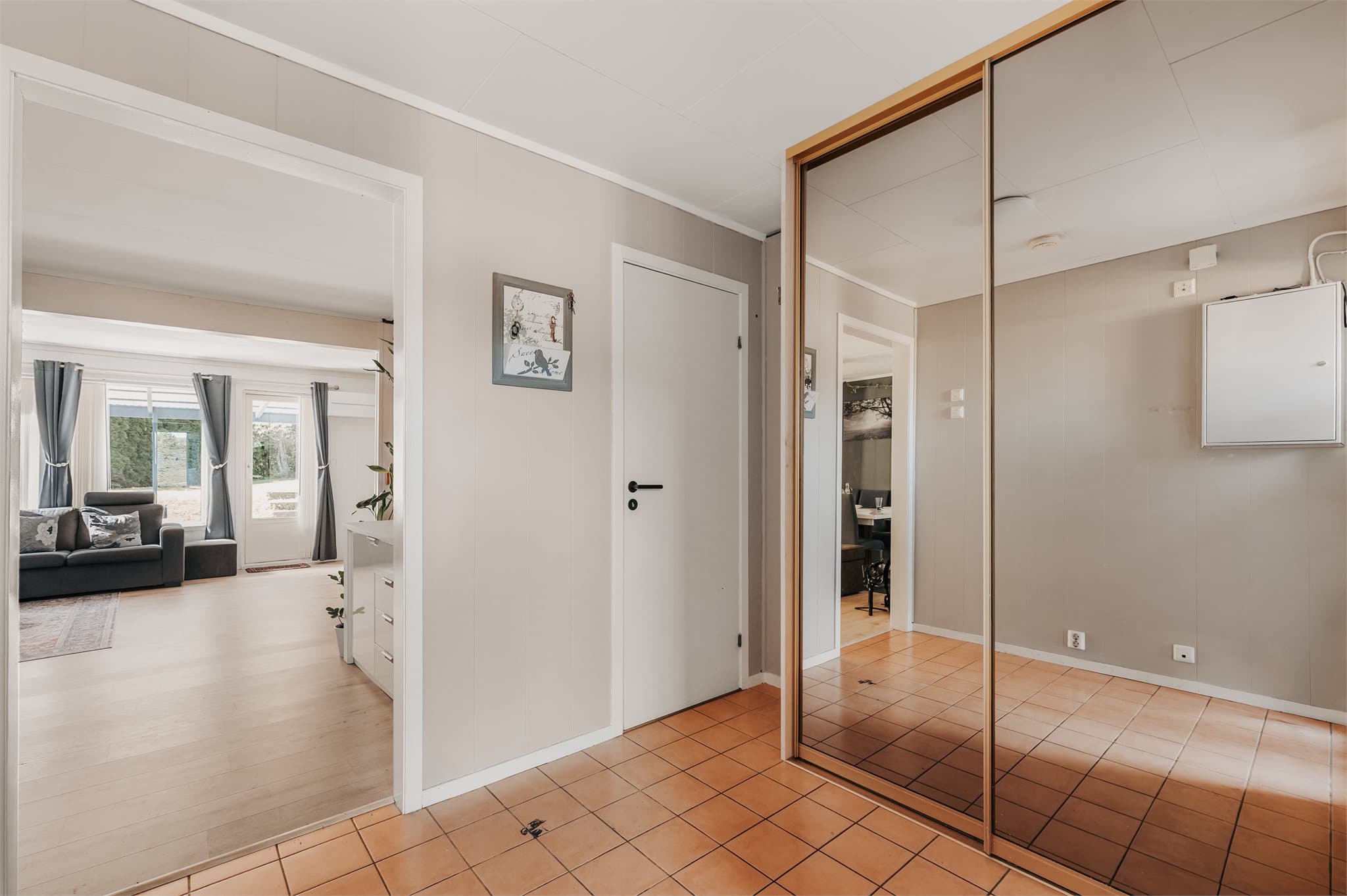 Velkommen inn! Lysmalt entré hvor man har skyvedørsgarderobe med speilfronter.