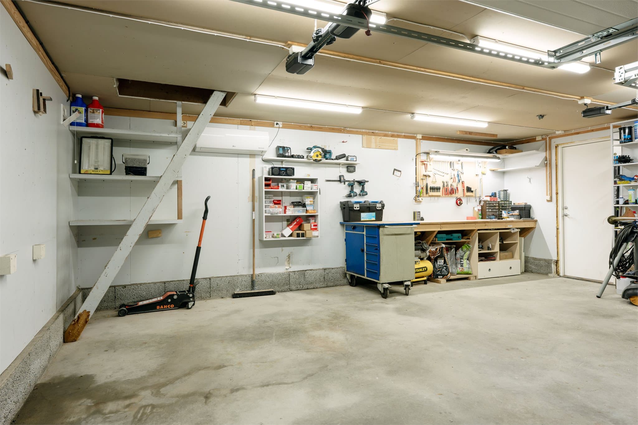 Garasjen fra 1990 har støpt betongplate, verkstedplass, varmepumpe og adkomst til lagerloft.
