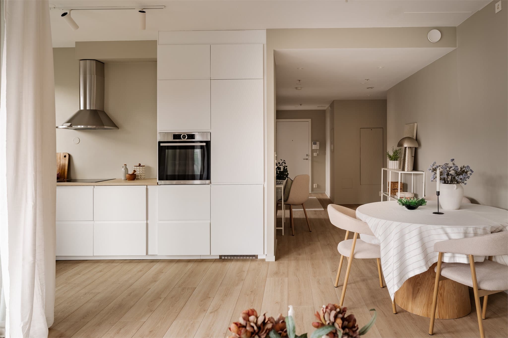 Kjøkkenet ligger i en åpen og sosial løsning mot stuen, og har en moderne innredning med glatte skapfronter, laminat benkeplate og nedfelt oppvaskkum i rustfritt stål