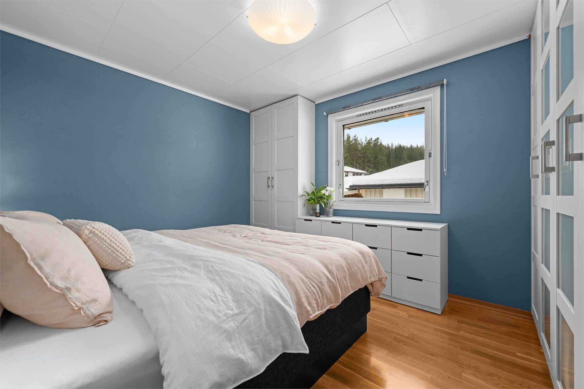 Dette soverommet har en nydelig blåtone og rikelig med garderobeplass.