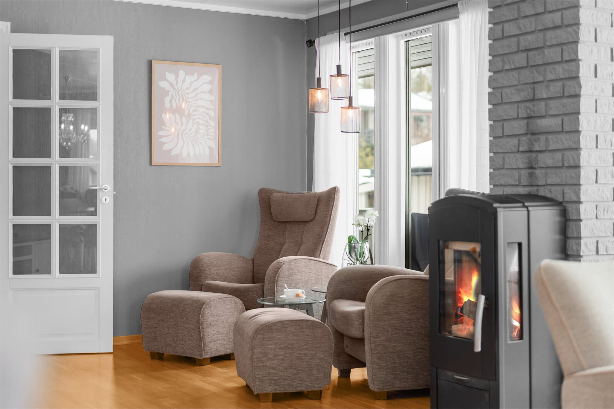 Nøytrale toner gjør innredningen enkel. I stuen er en deilig peisovn som varmer godt.