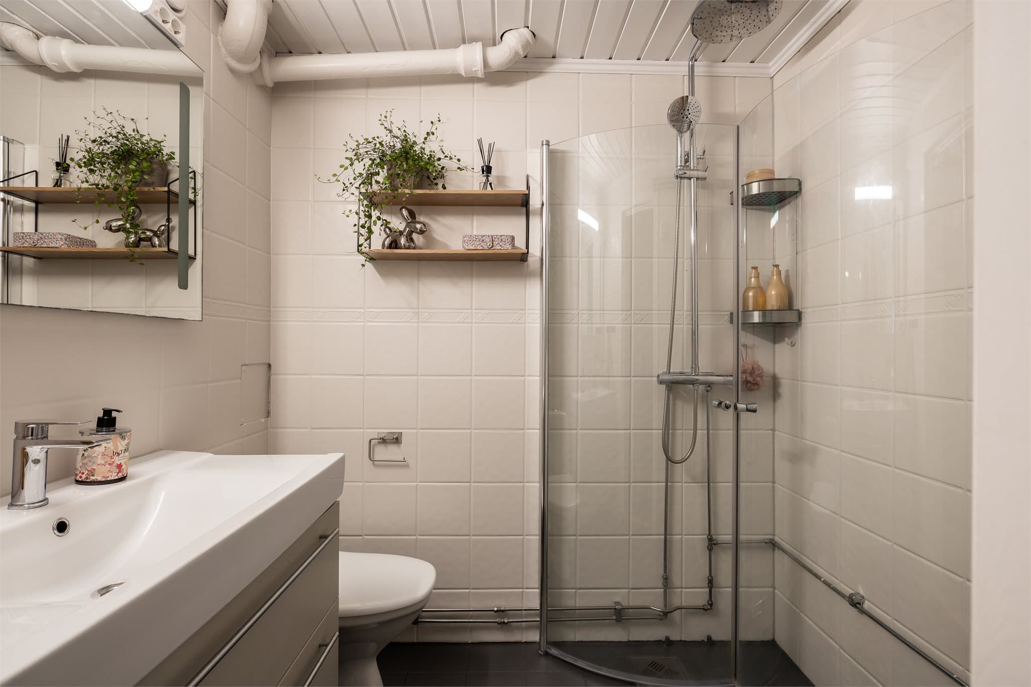 Badet er utstyrt med dusjhjørne, toalett, servantinnredning og har opplegg for vaskemaskin.