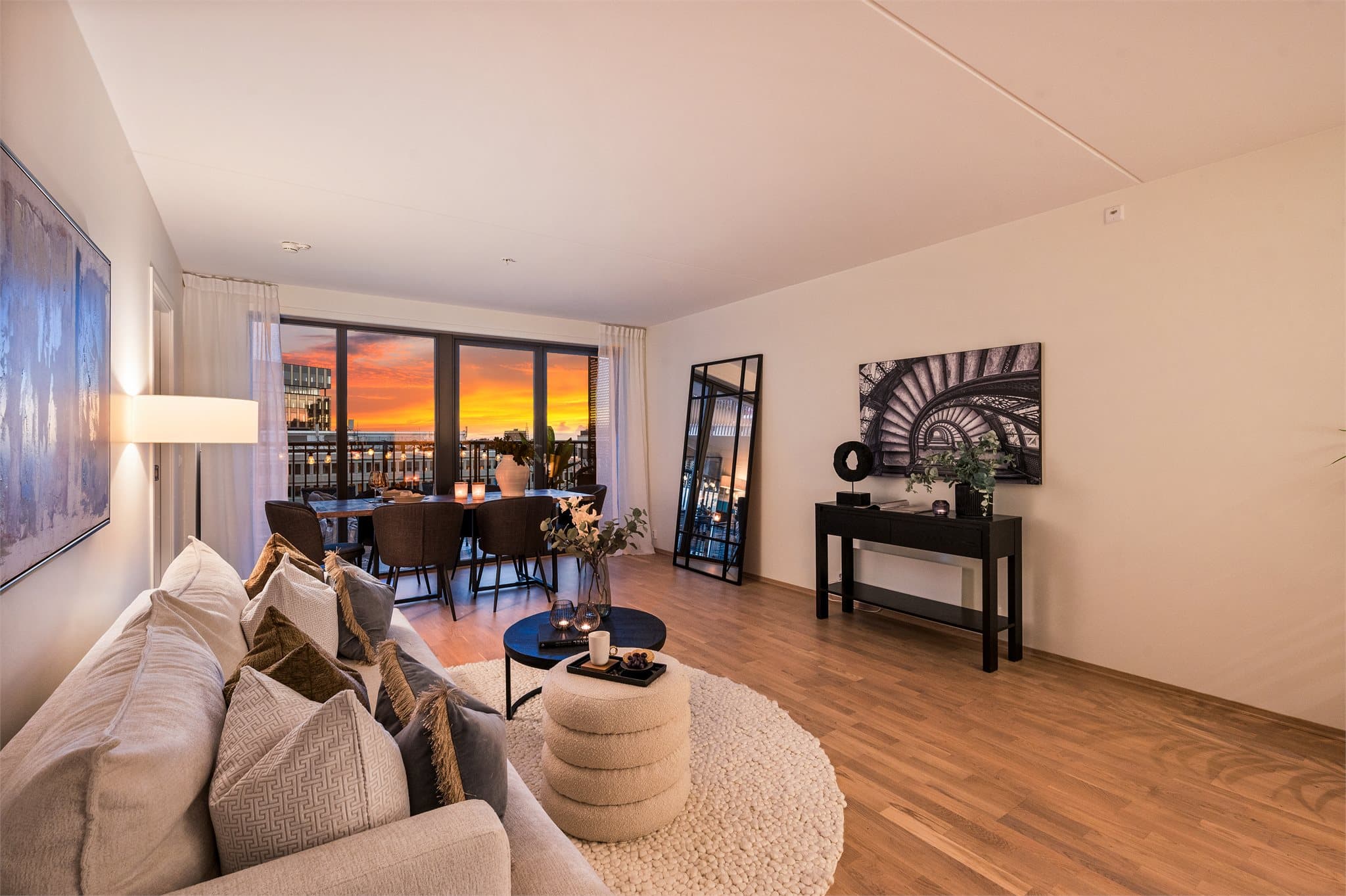 Leiligheten har en lys og moderne stue med store vindusflater som skaper en åpen og luftig romfølelse.