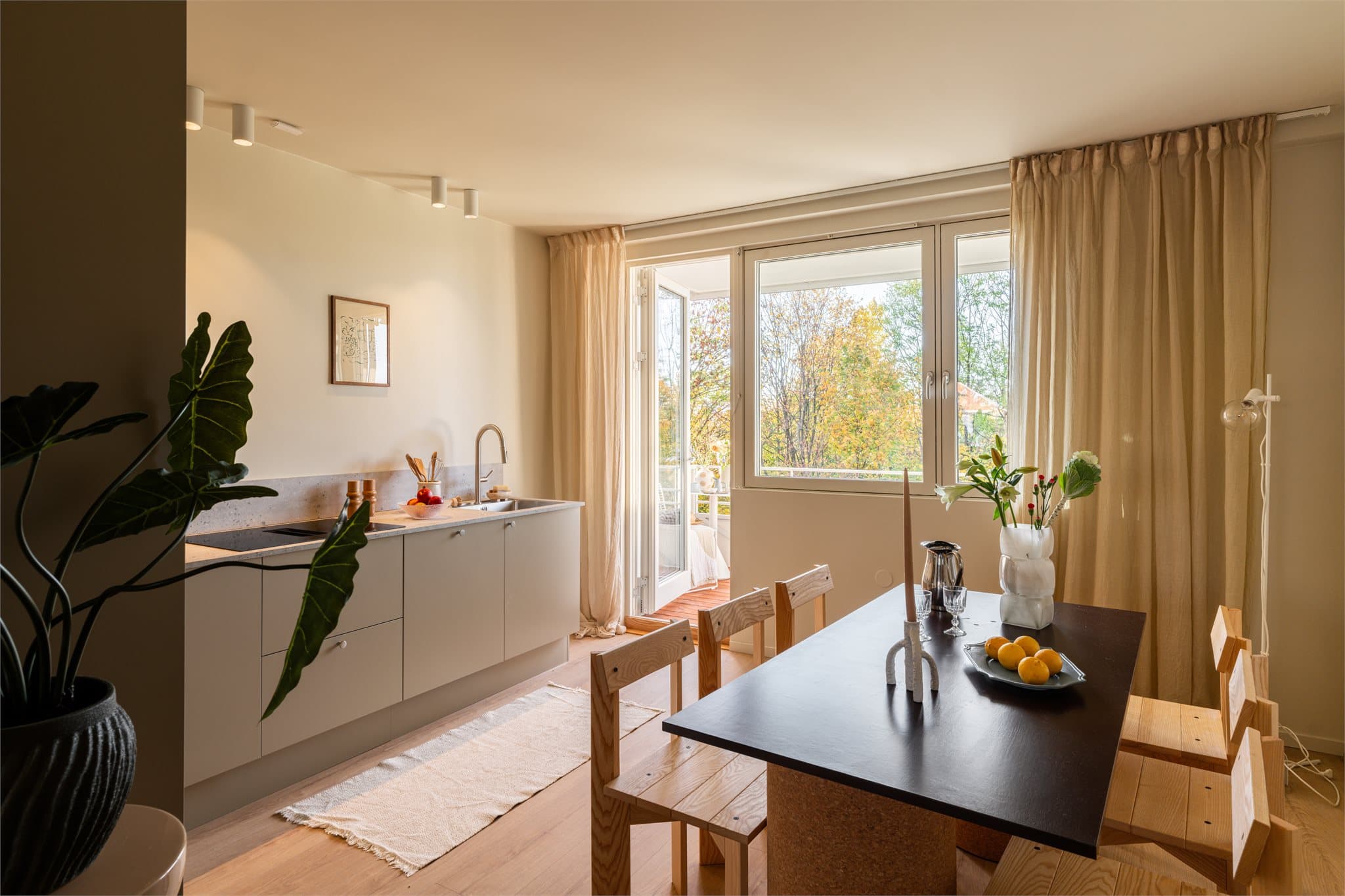 Svanekjøkken med en gjennomført look og naturlig plass til spisebordet.