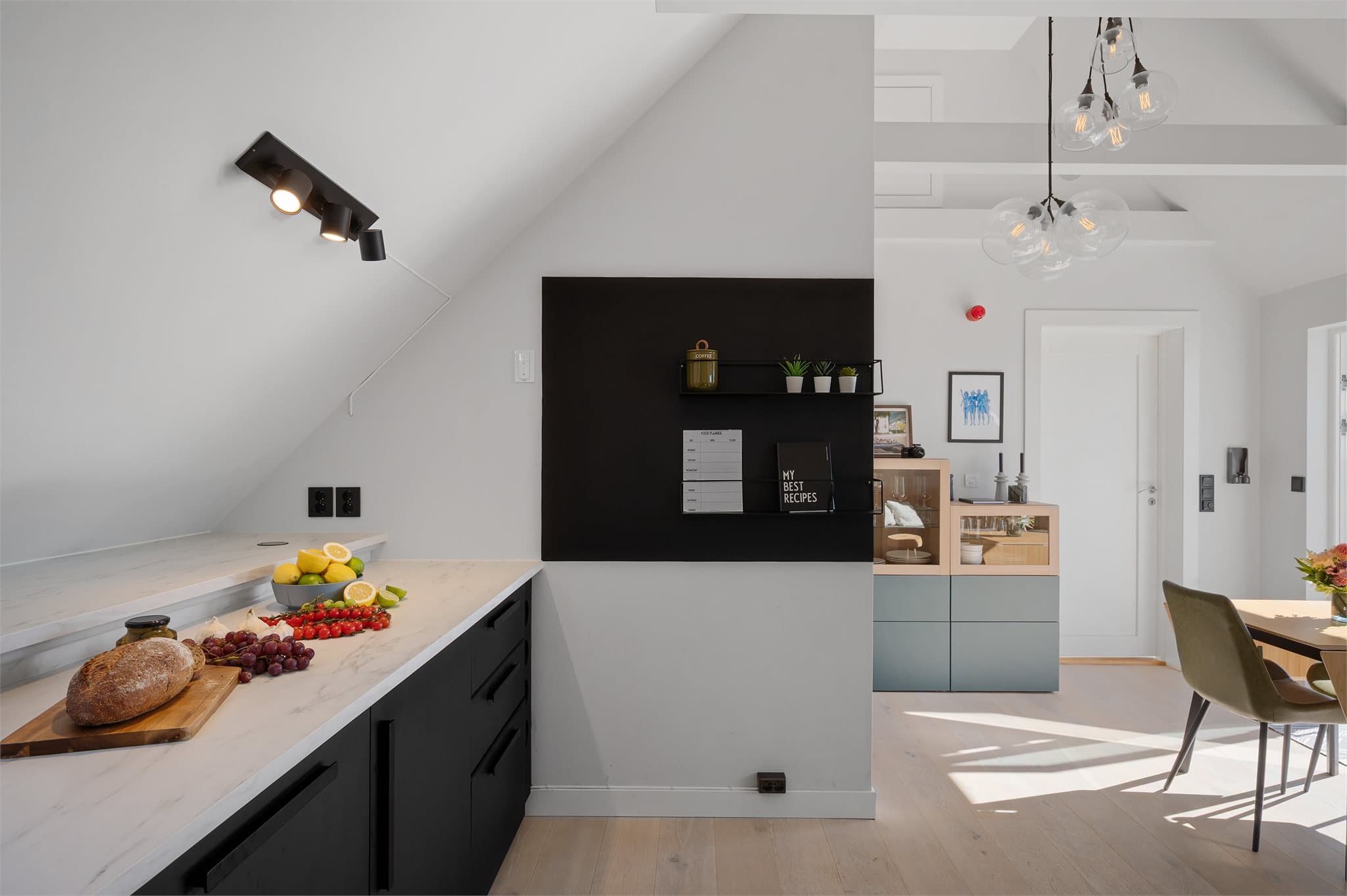 - Kjøkkenet fremstår stilrent med sorte overflater, hvor gjennomgående detaljer som sorte stikkontakter bidrar til et helhetlig og harmonisk uttrykk -