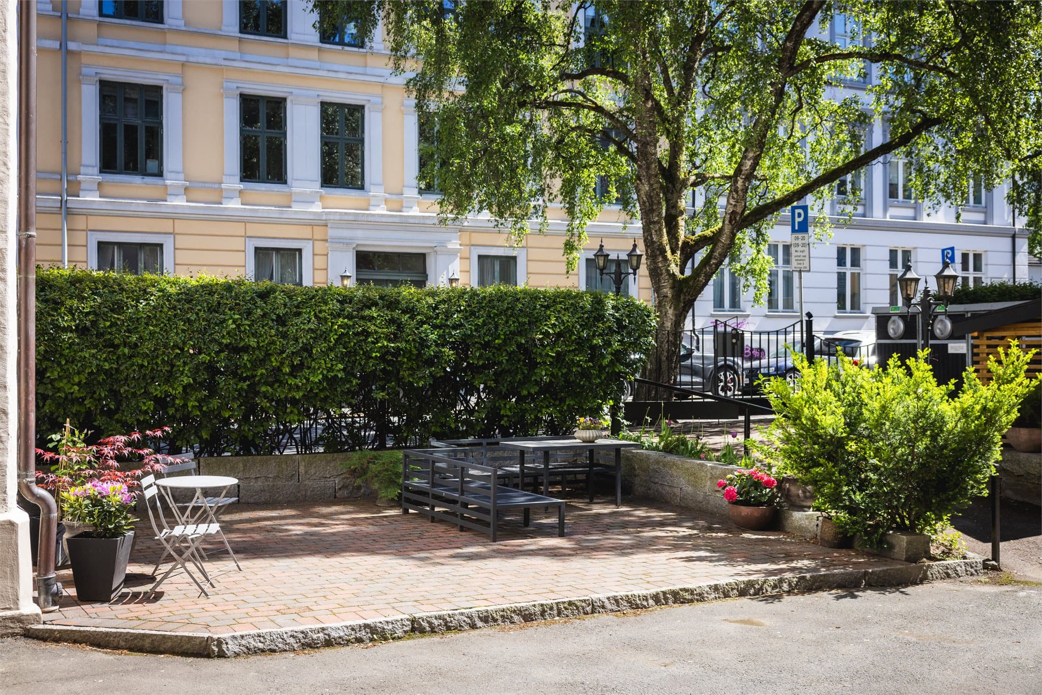 Gårdsrommet er pent opparbeidet med sittegrupper, brostein og beplantning.