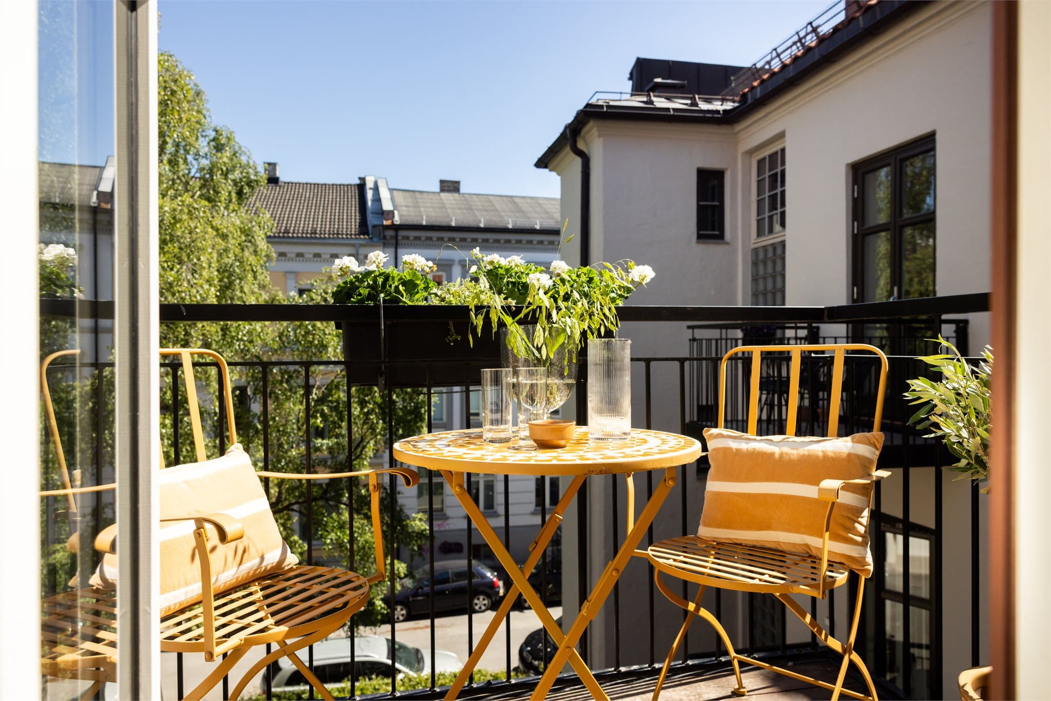 Innbydende og luftig balkong som vender ut mot frodig gårdsrom.